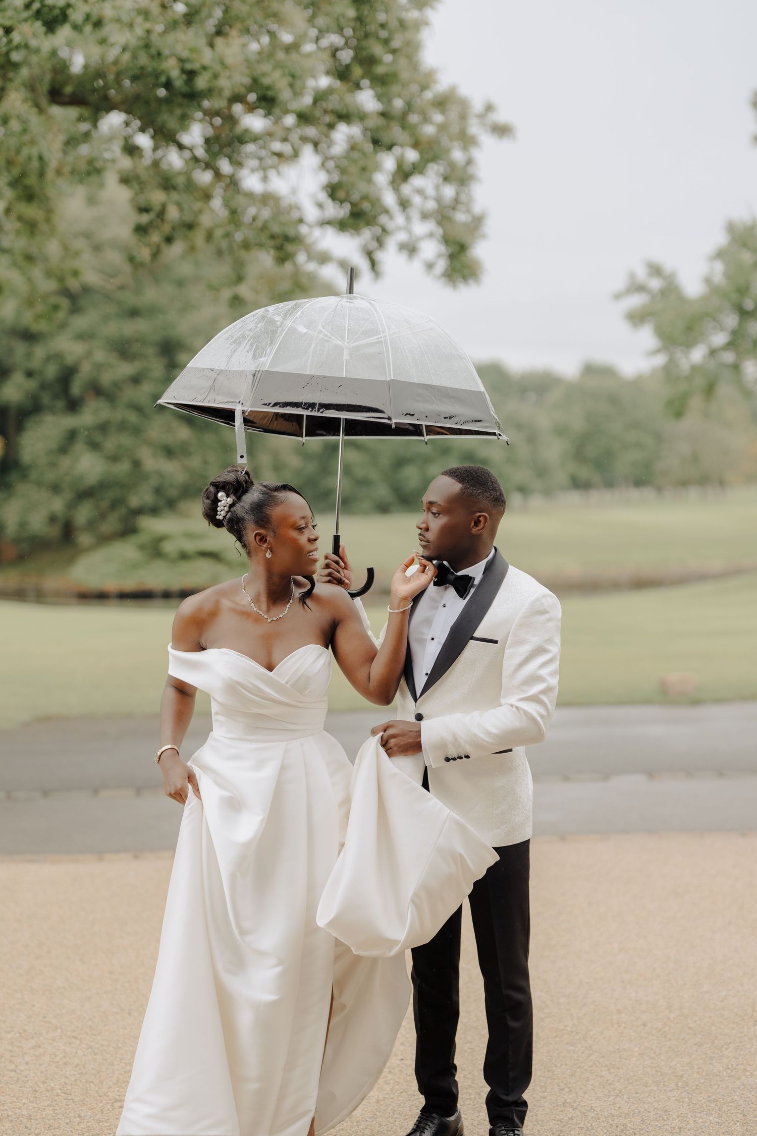 Romantic couple sharing an intimate moment under an umbrella in an outdoor setting.