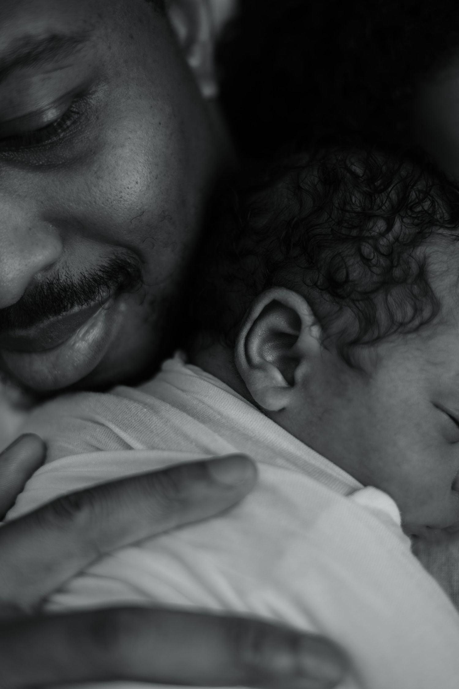 Black and white image of intimate family moments with a newborn.