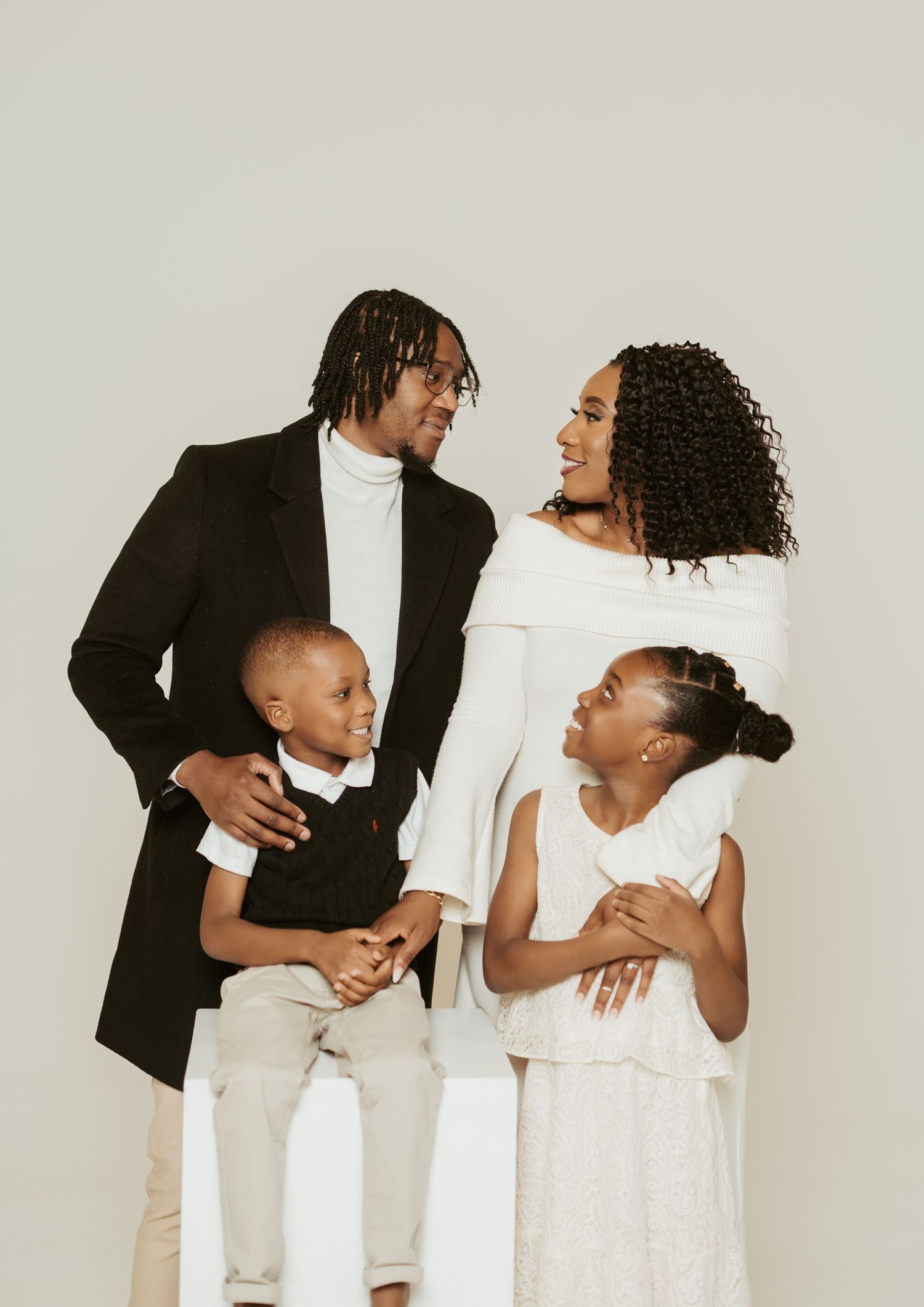 Studio family portrait with black and white color scheme showing playful interactions.