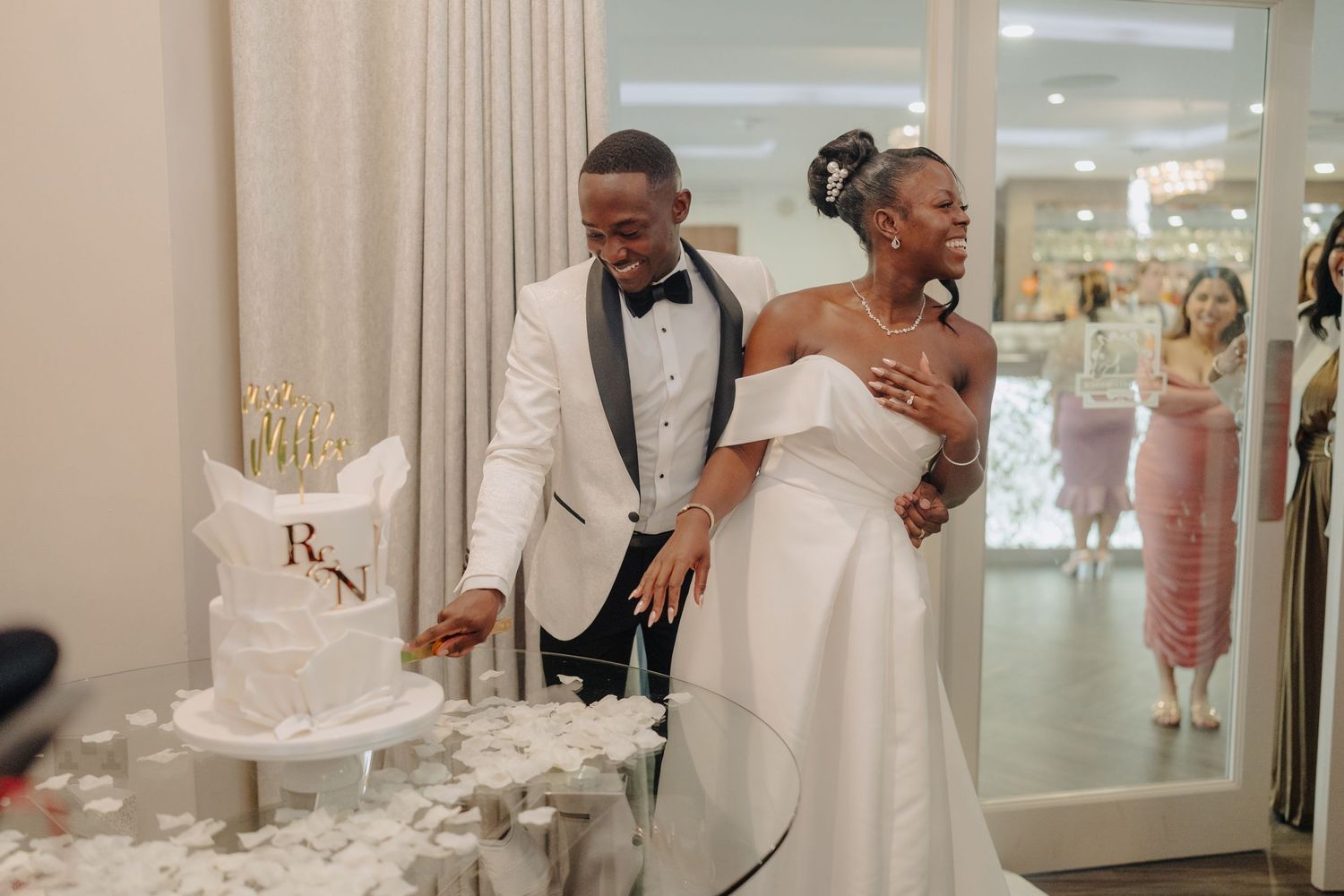 Elegant wedding reception with white decor and floral arrangements in modern venue.