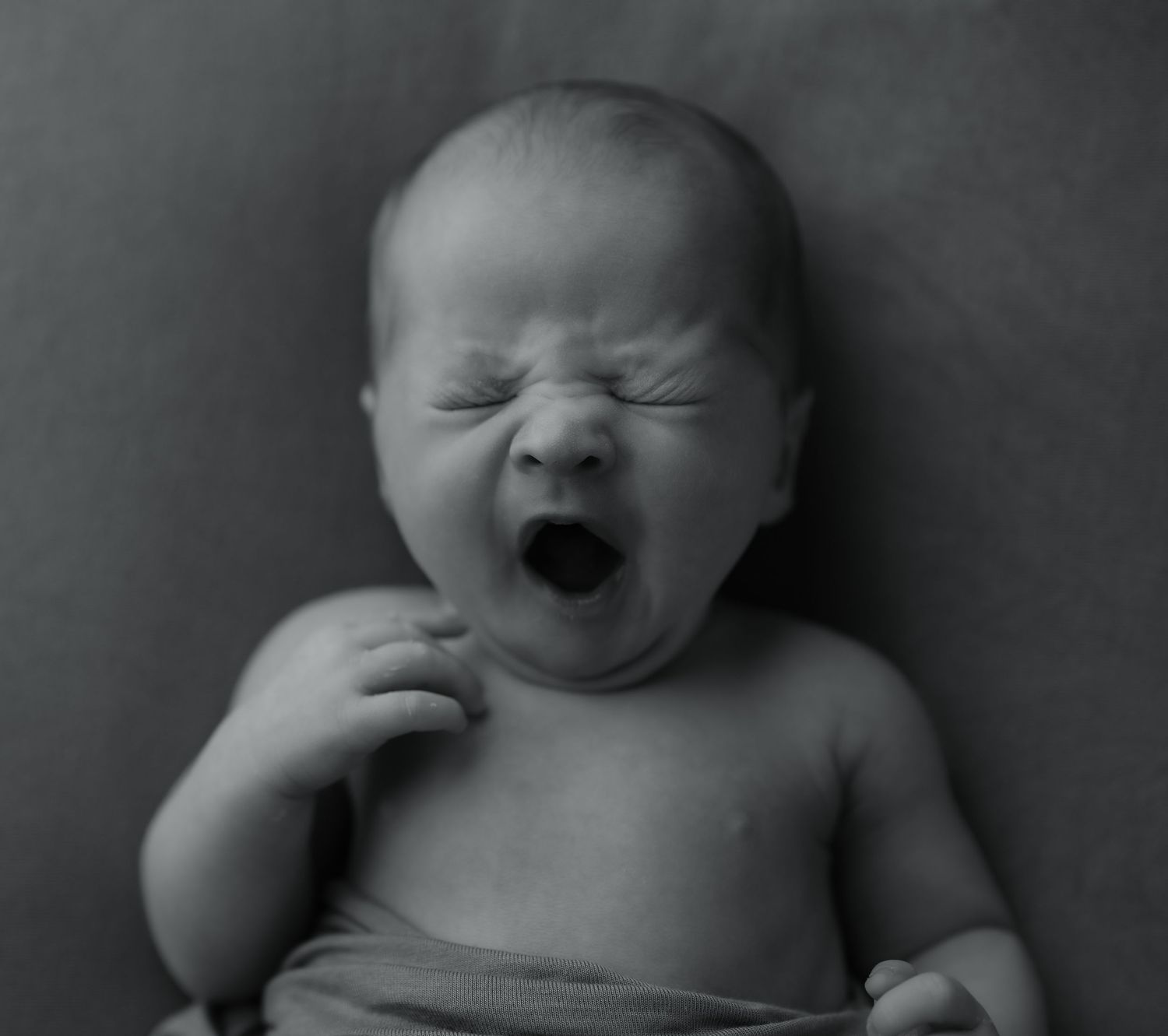 Black and white series showing different expressions of a newborn baby.
