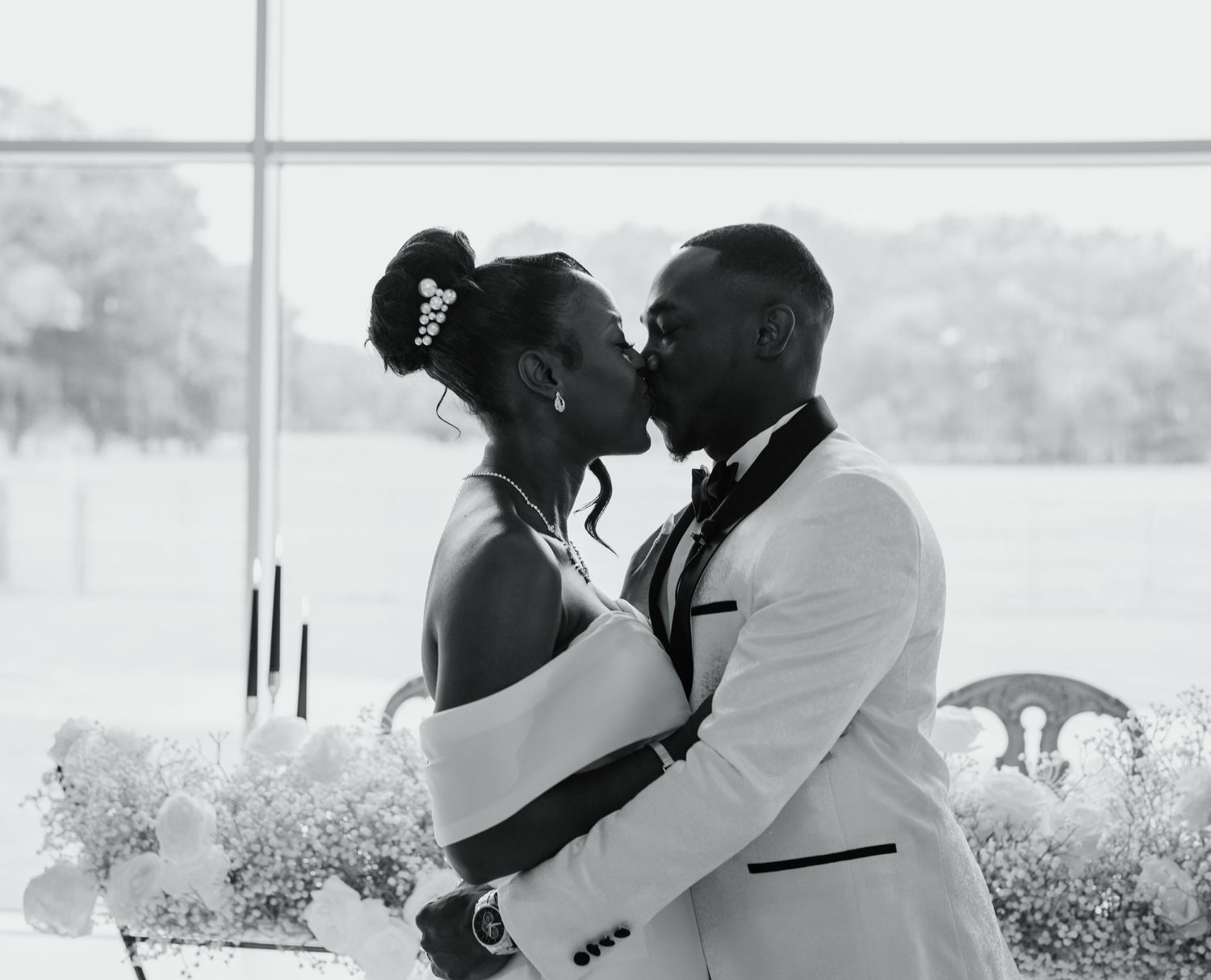 Black and white wedding photo captures an intimate moment between newlyweds.