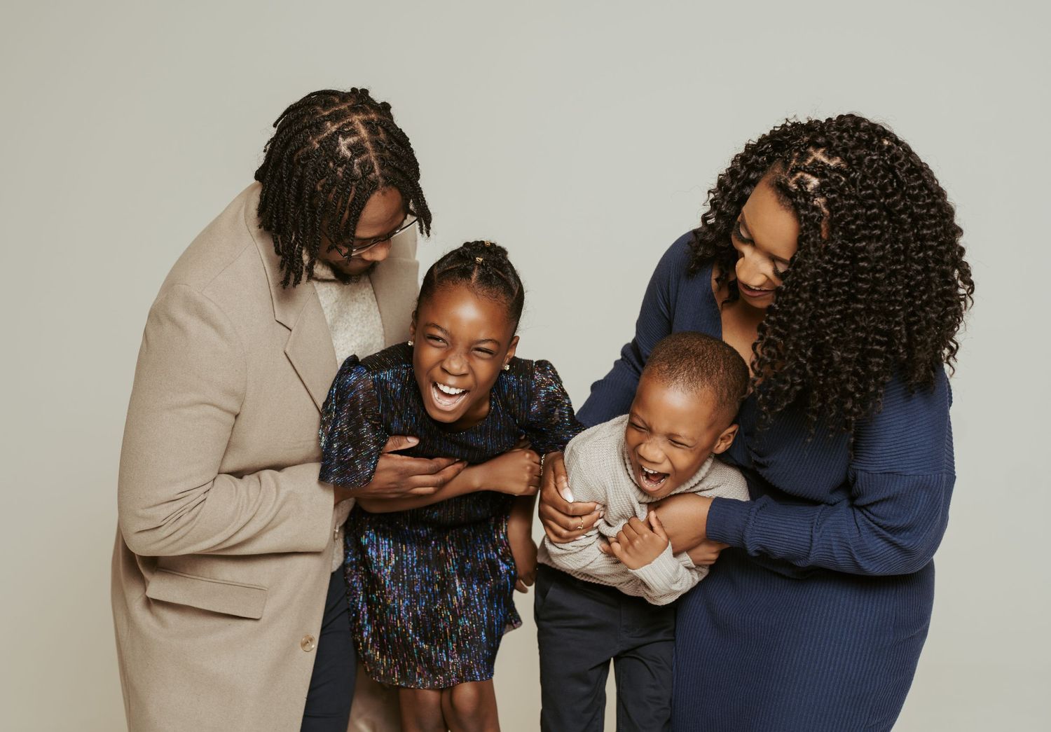 Studio portrait series showing joyful family interactions against neutral background.