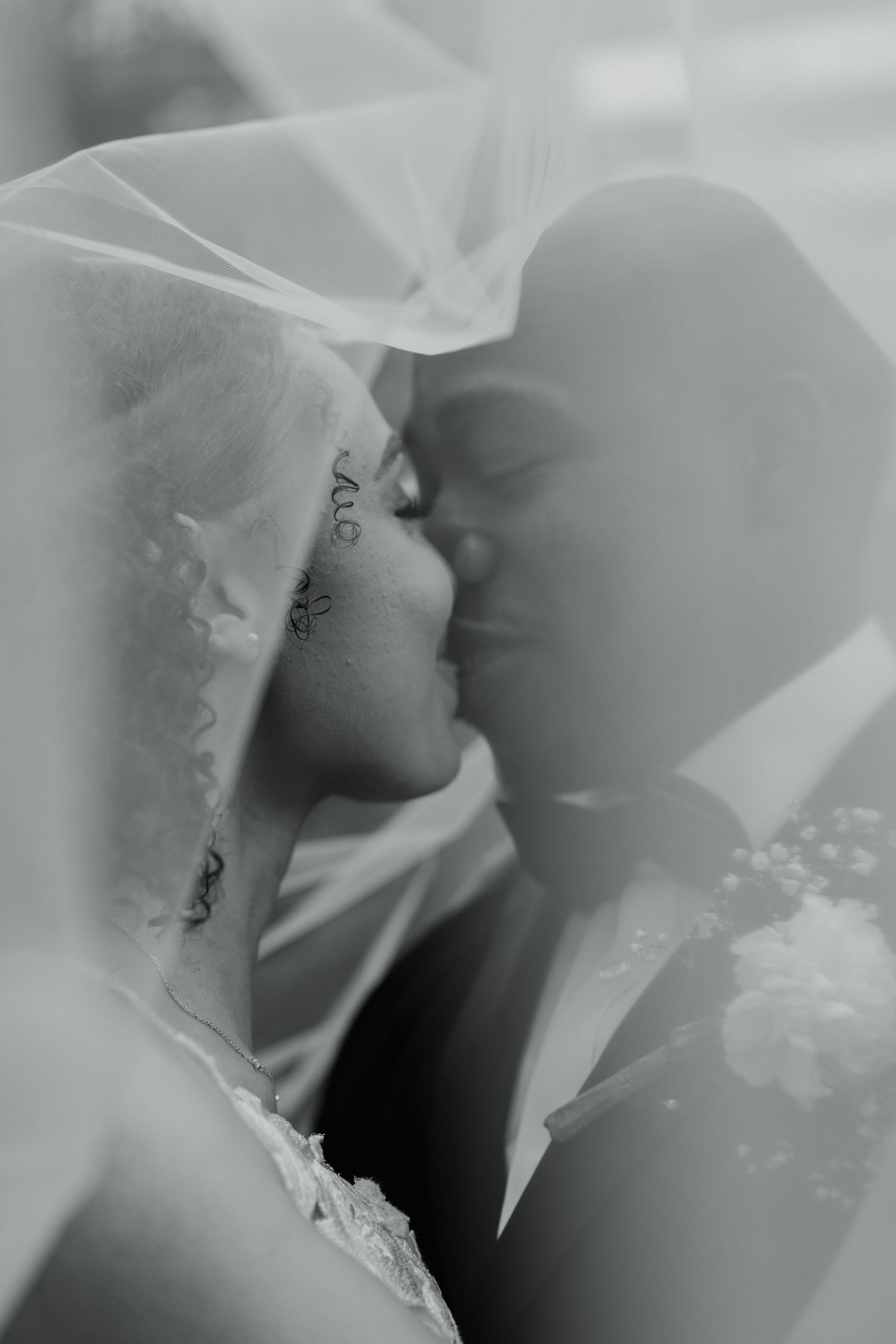 Ethereal close-up of delicate white wedding dress details in soft focus.