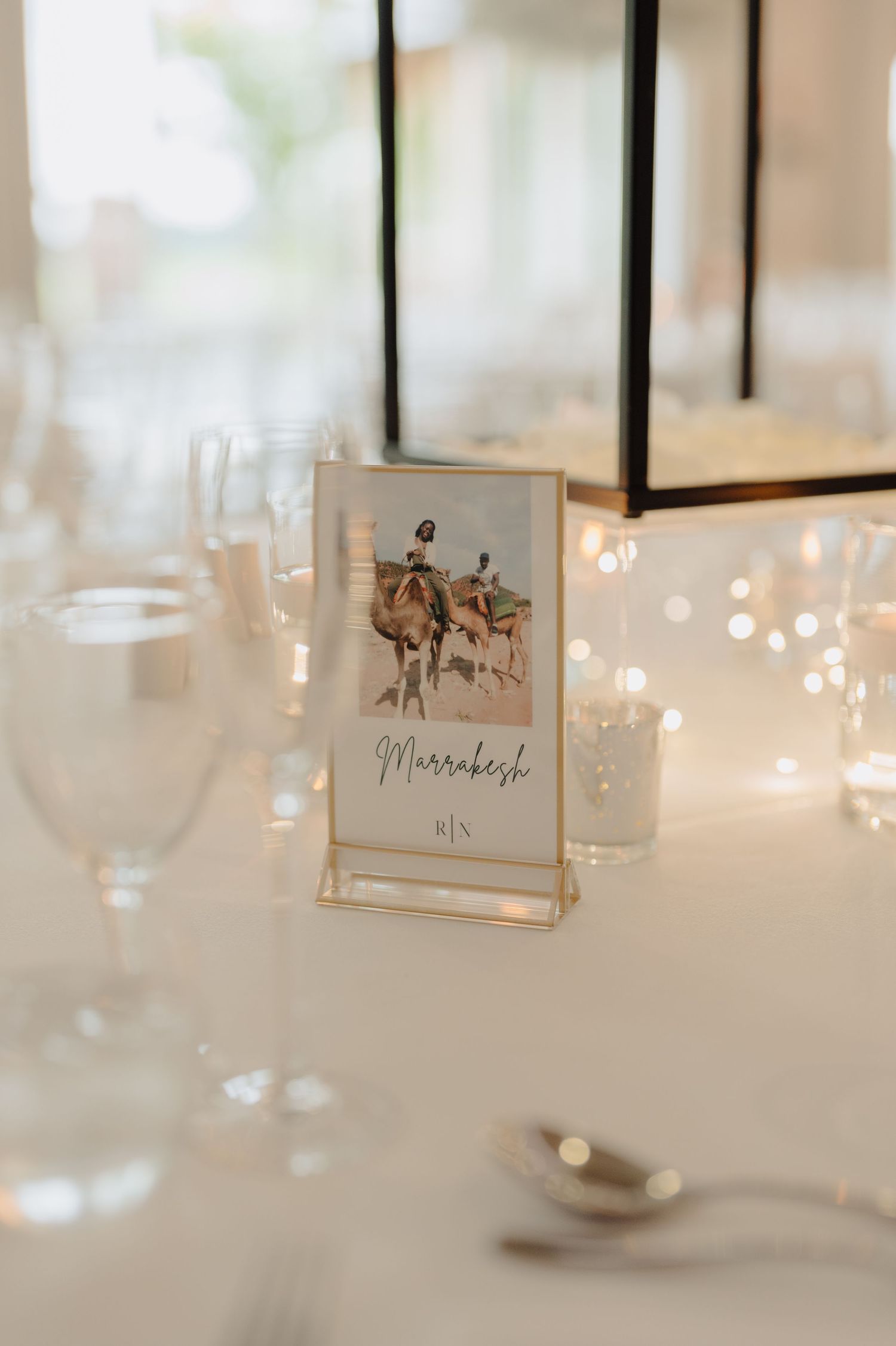 Wedding reception table details with soft candlelight and framed place cards.
