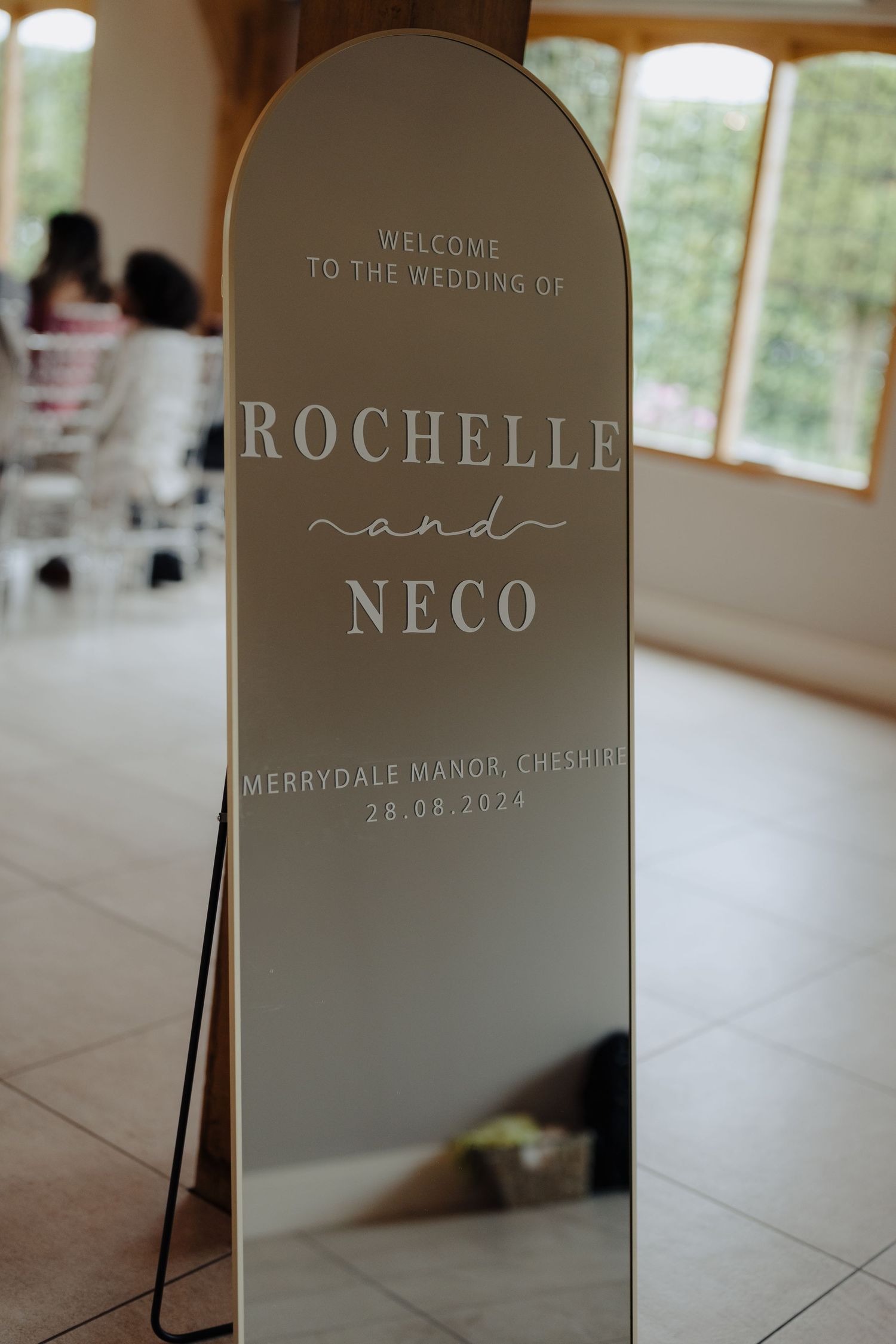 Elegant arched welcome sign for Rochelle and Neco's wedding at Merrydale Manor in Cheshire.