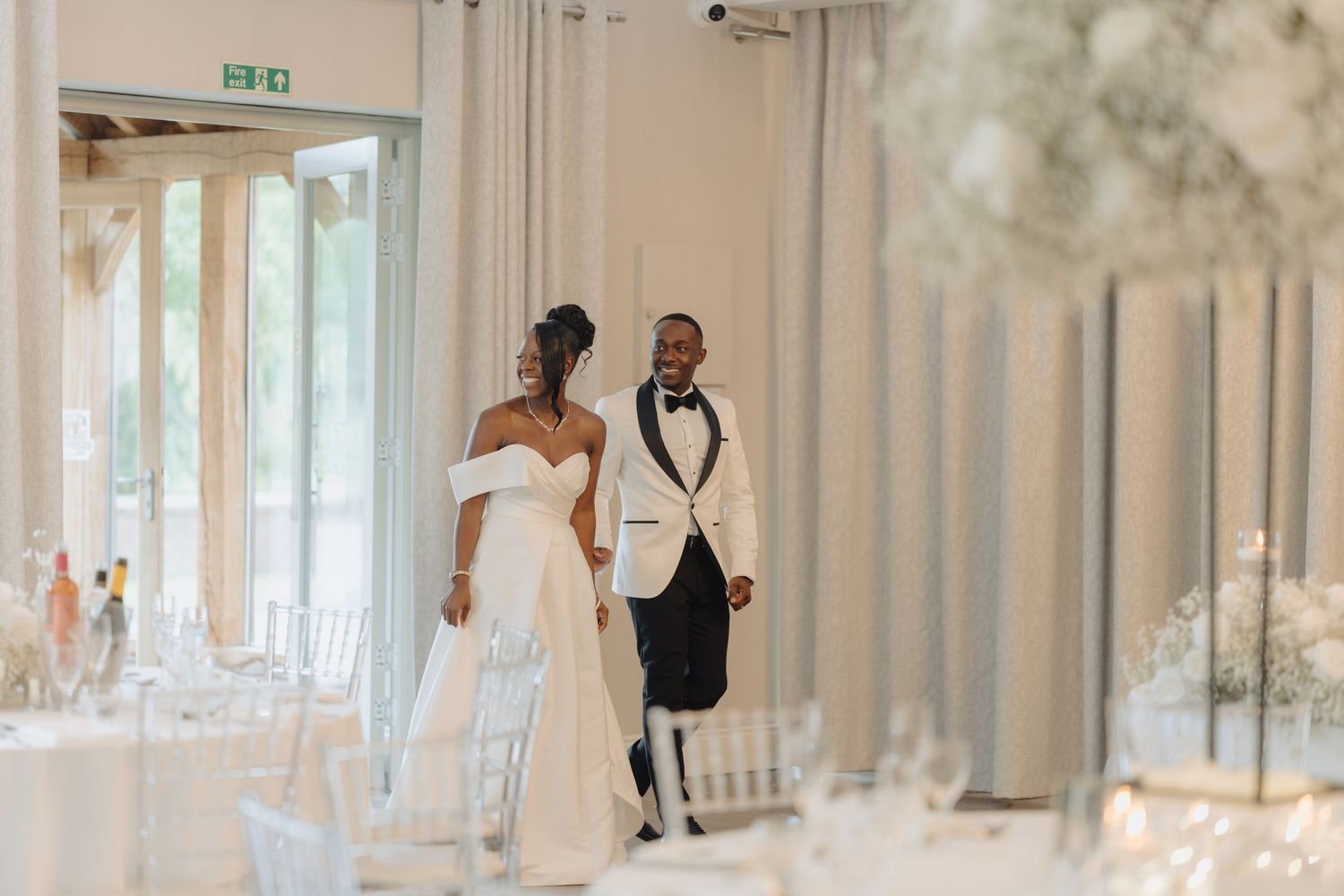 White and gold decorated wedding reception space with elegant table settings.