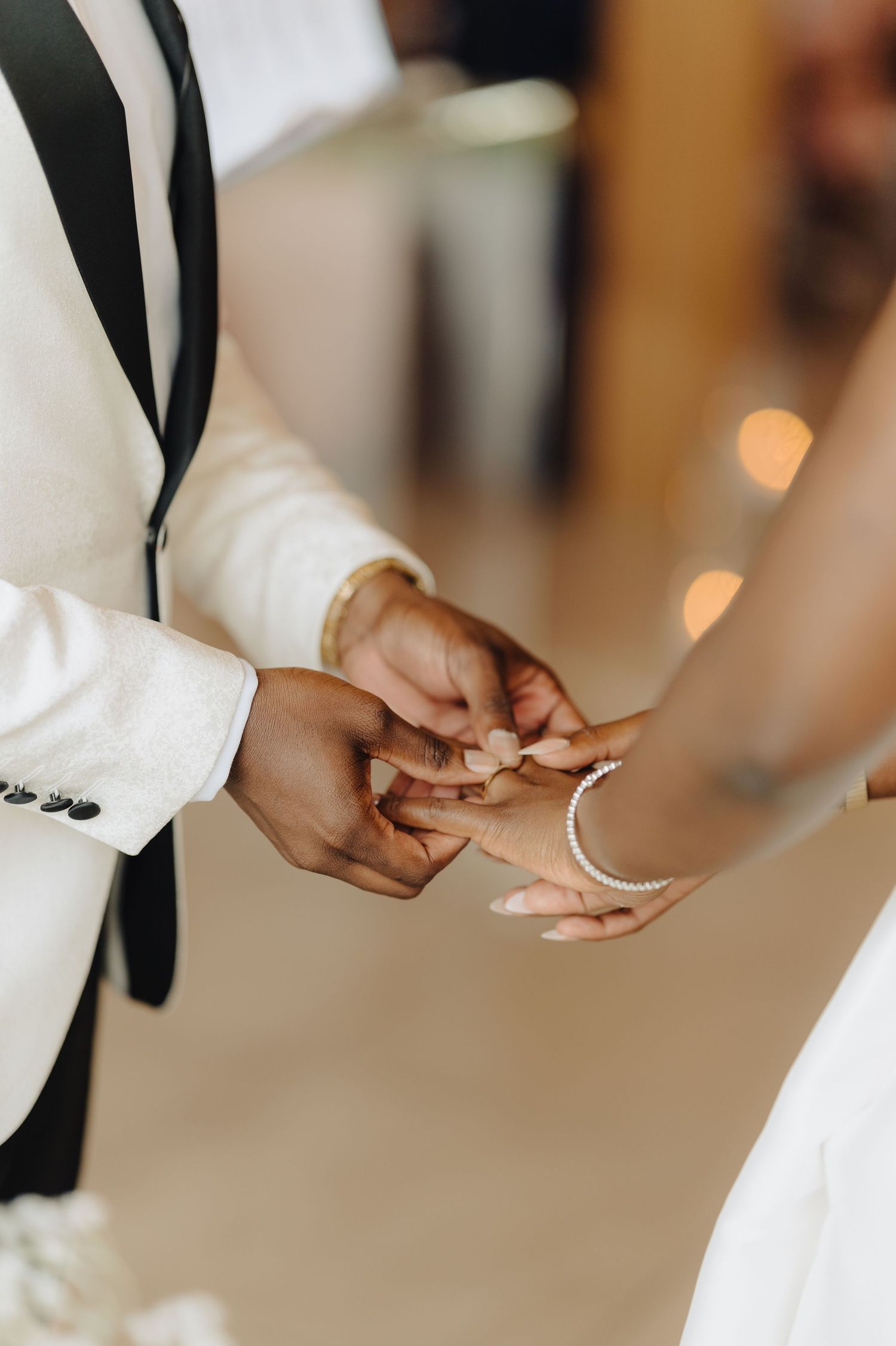 Close-up of hands exchanging rings during a wedding ceremony.