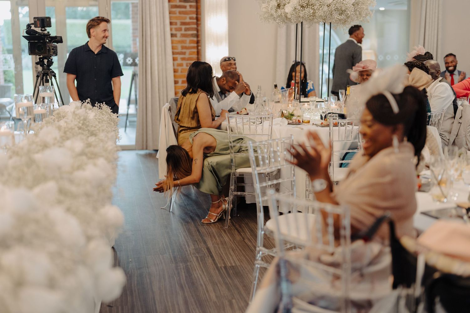 Wedding venue decorated with white floral arrangements and elegant table settings.
