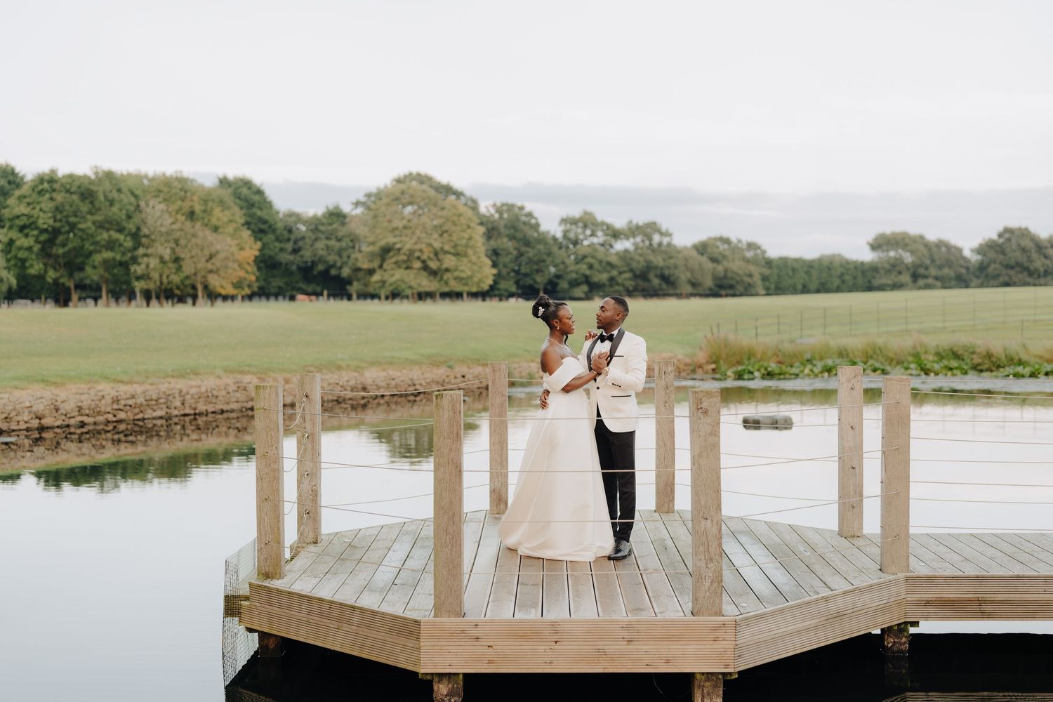 Scenic lakeside wedding venue with wooden dock and expansive water views.