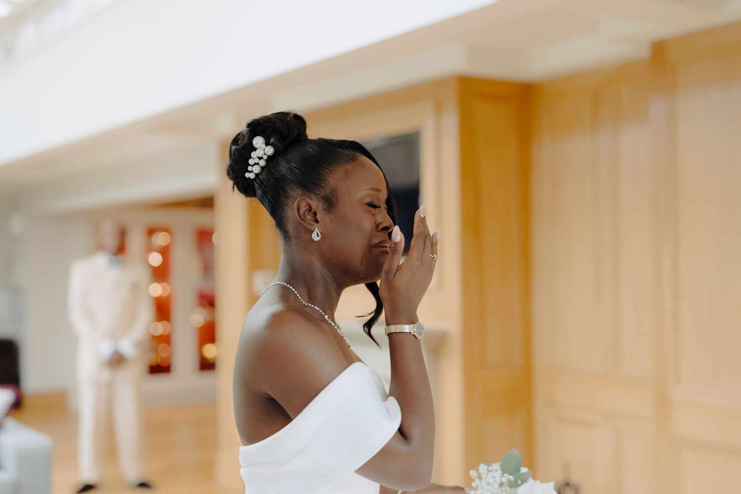 Emotional moment during wedding preparations as people share tears and embraces in a warmly lit room.