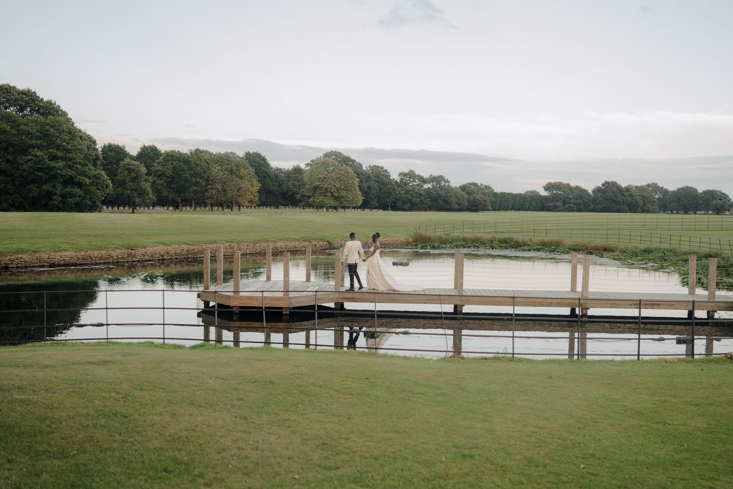 Panoramic view of a lakeside wedding venue with wooden dock and natural surroundings.