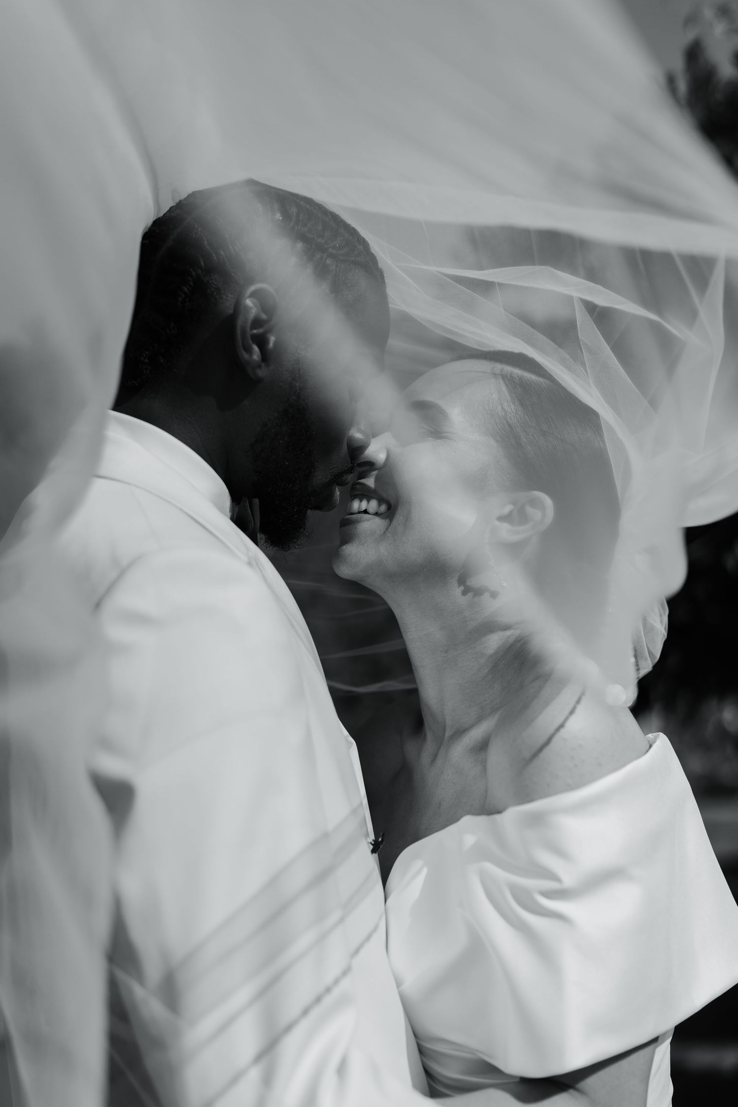 Romantic black and white wedding moments captured under a flowing veil.