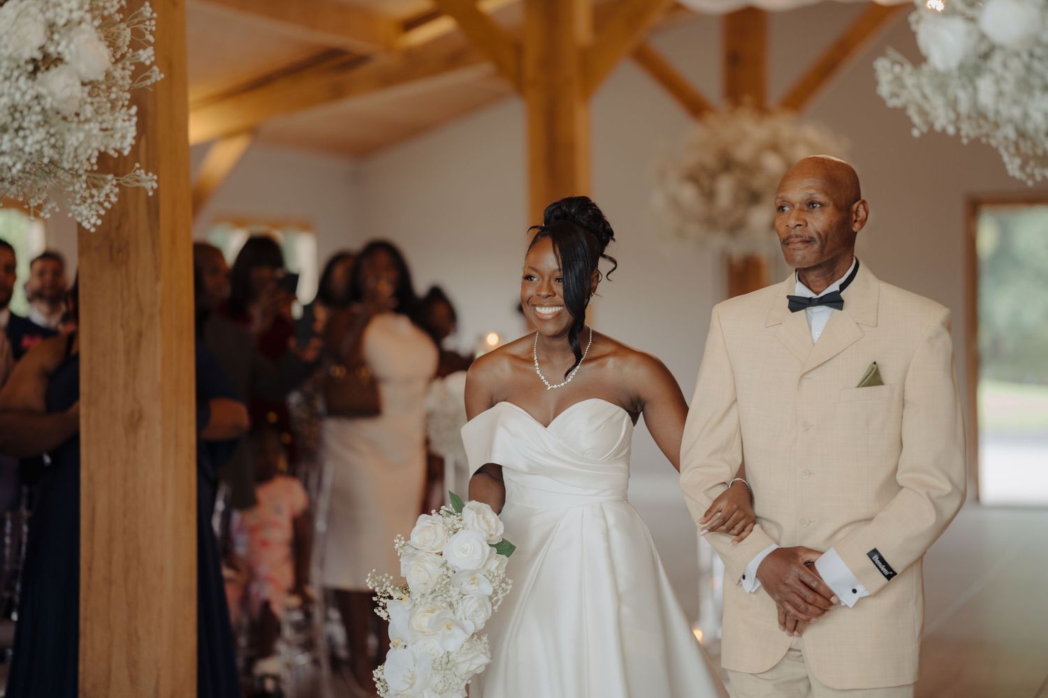 Wedding celebration in a rustic venue decorated with white flowers and crystal chandeliers.