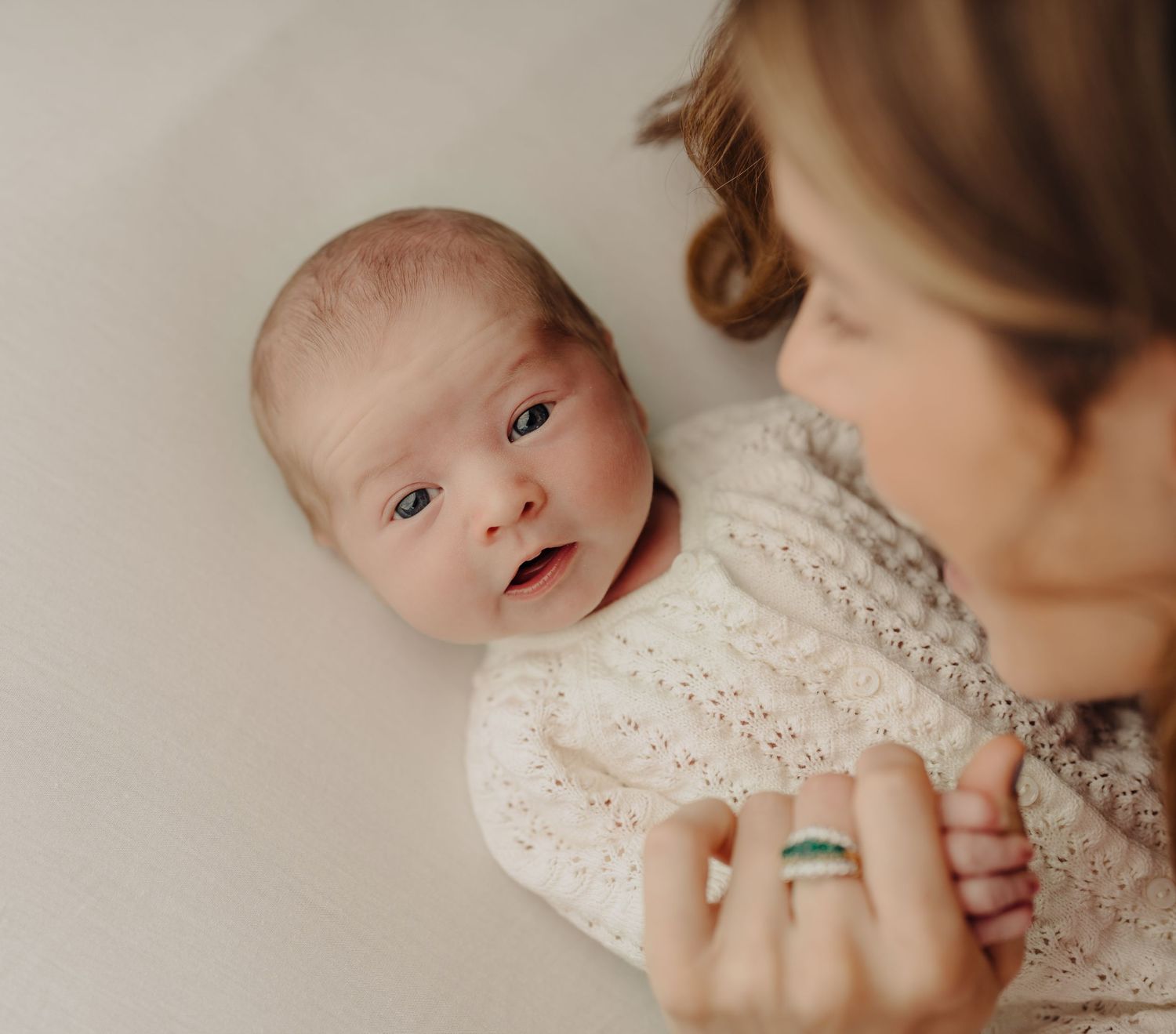 Close-up photo series of a baby in lace clothing showing various expressions.