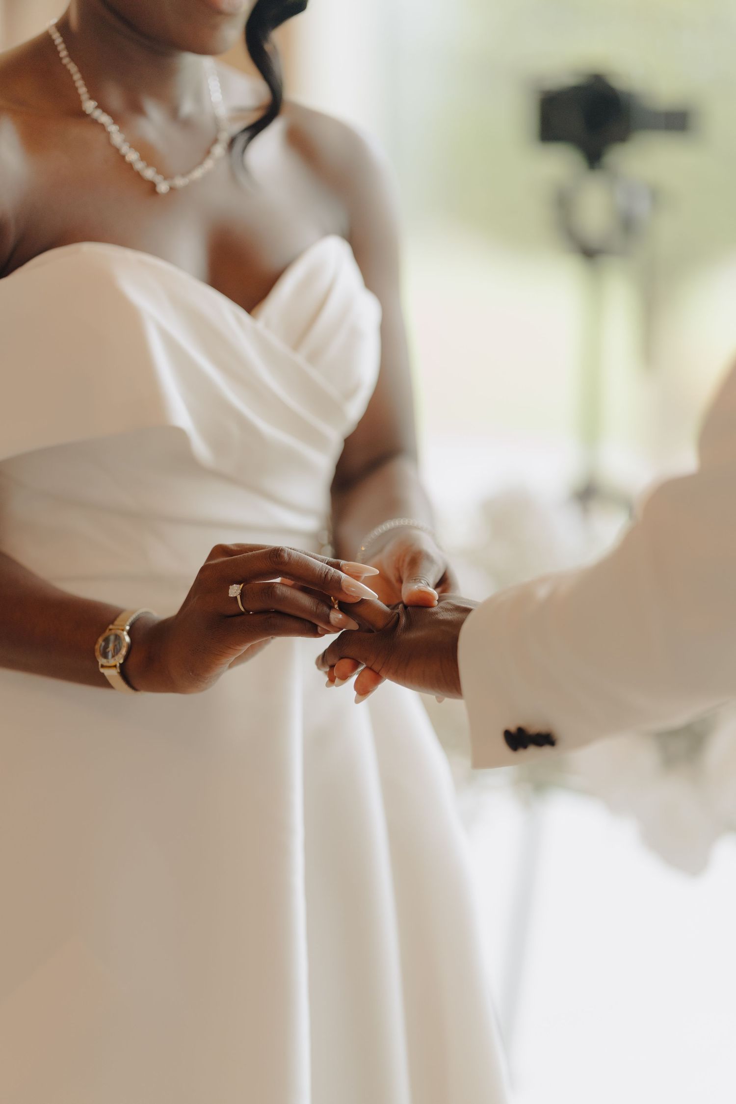 Elegant details of a white wedding dress and jewelry during the ceremony.