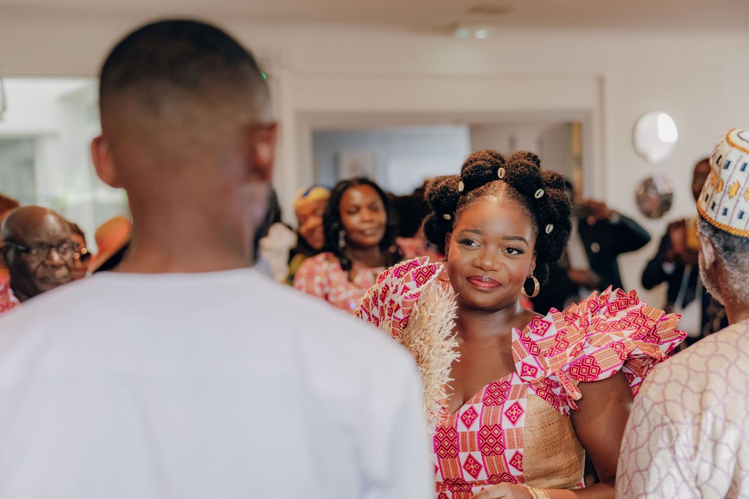 Attendees at a formal indoor celebration wearing traditional African formal attire.