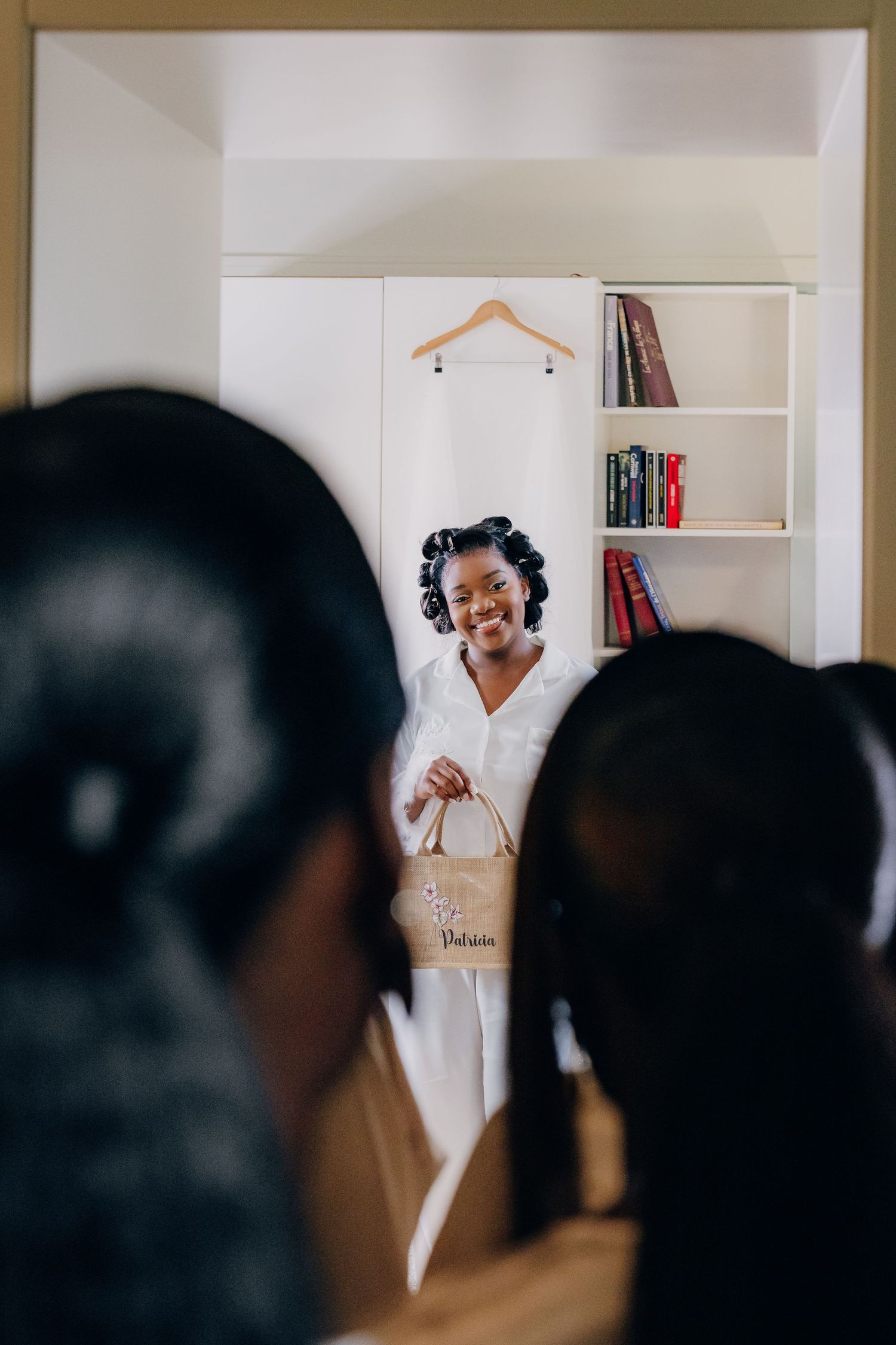 Wedding preparation scene with white dress visible in background.