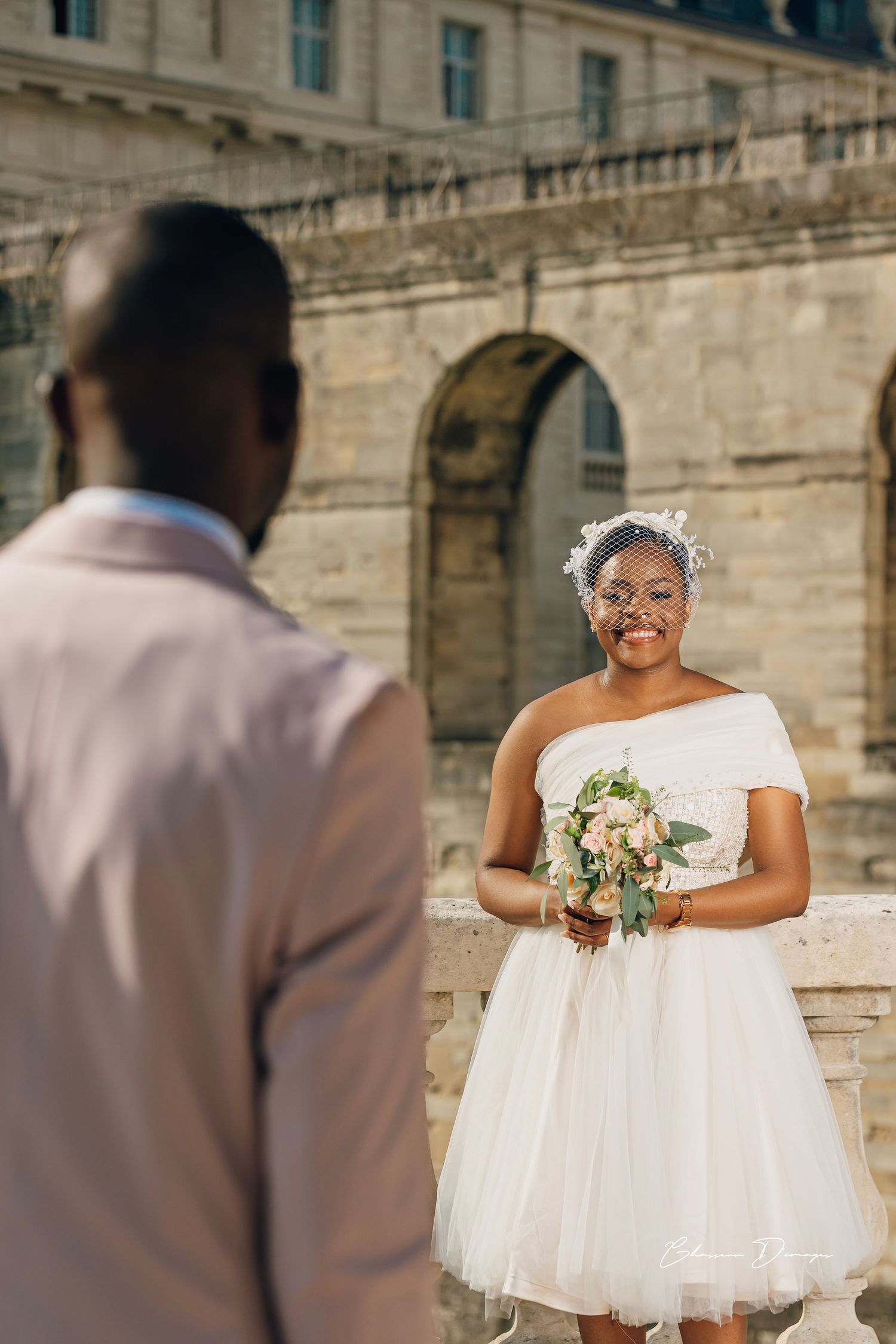 Romantic wedding portrait in front of historic stone architecture.