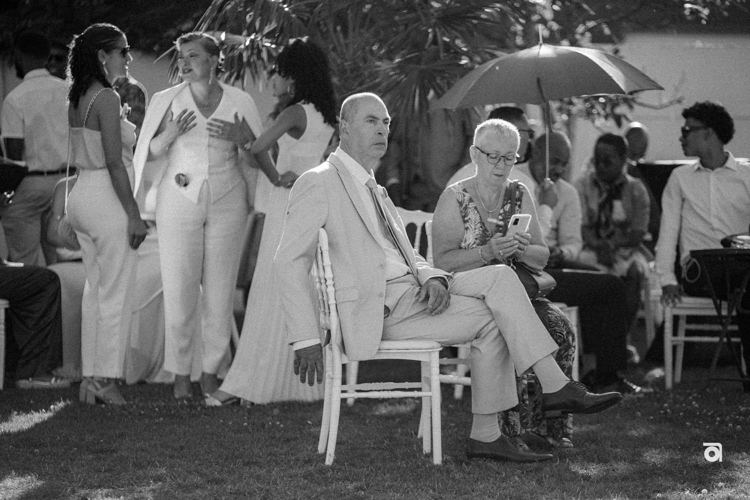 Black and white photograph of guests seated outdoors at a formal event.