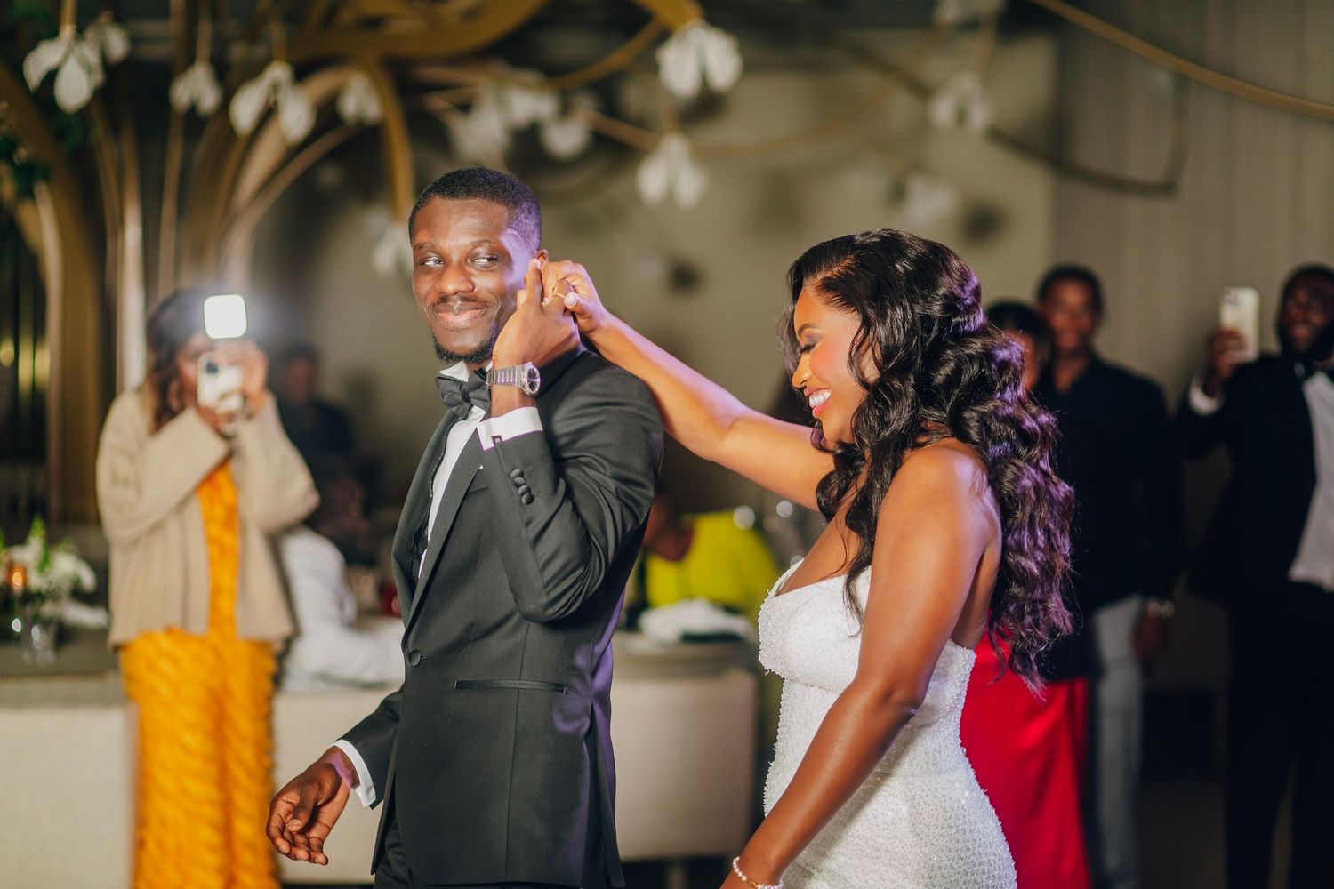 Wedding reception dance moment captured in warm indoor lighting.