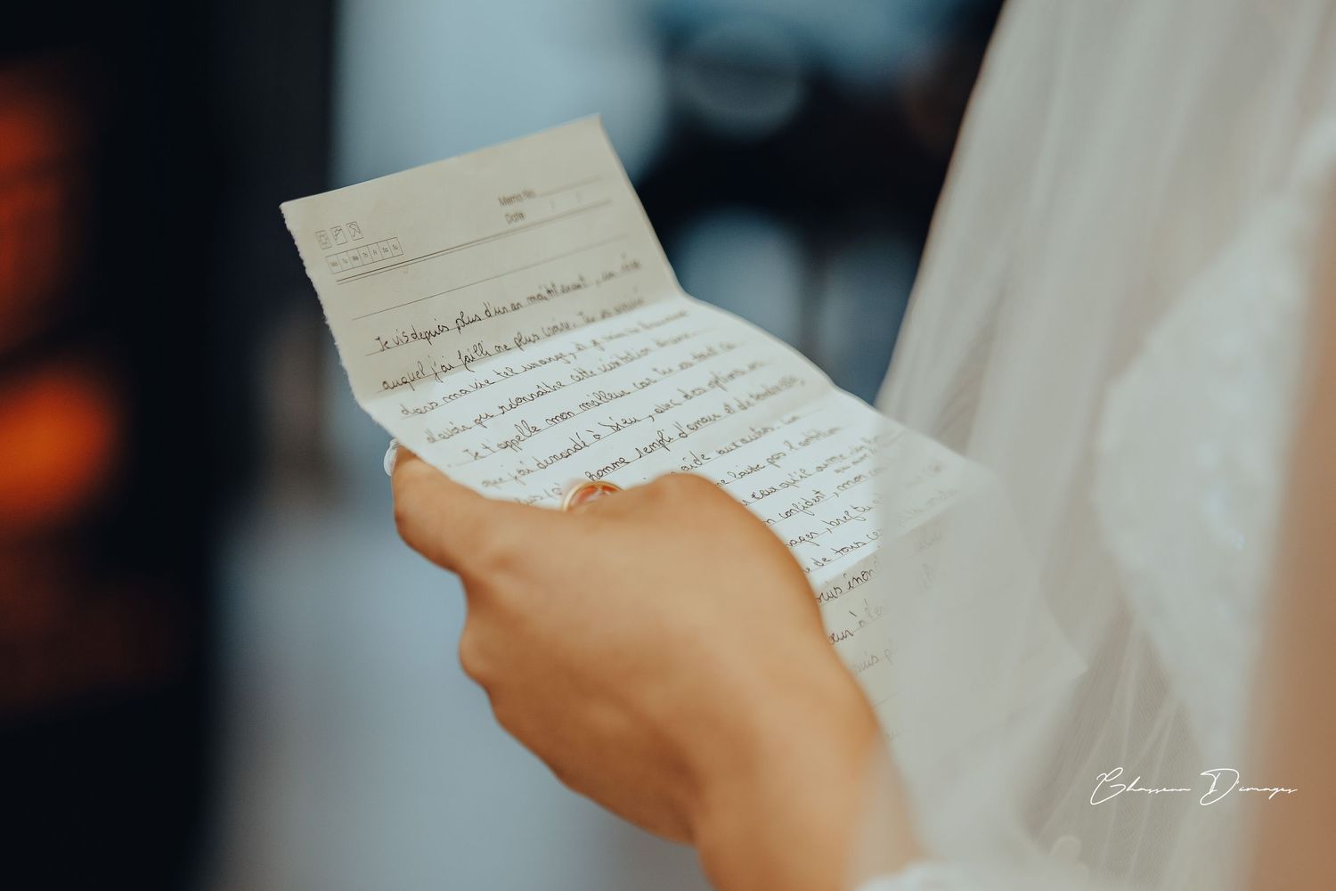 Handwritten wedding vows being read from paper against dark background.