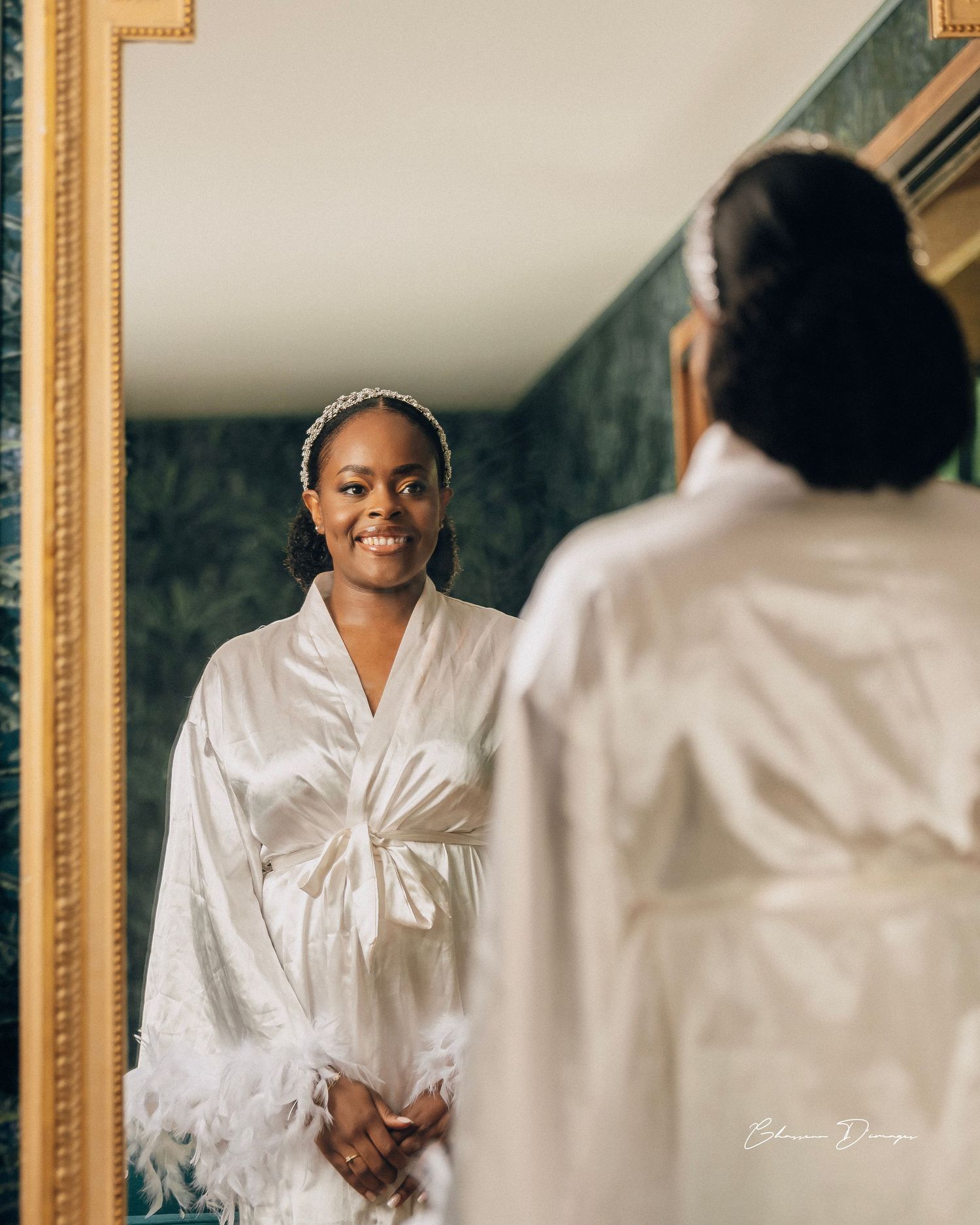 Getting ready moment reflected in mirror while wearing white silk robe.