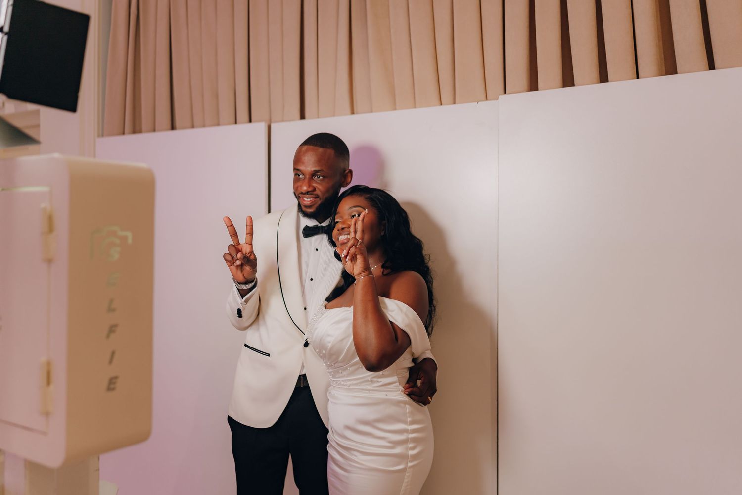 A series of photos showing a couple in a white and black outfit celebrating and posing together against a beige wall.