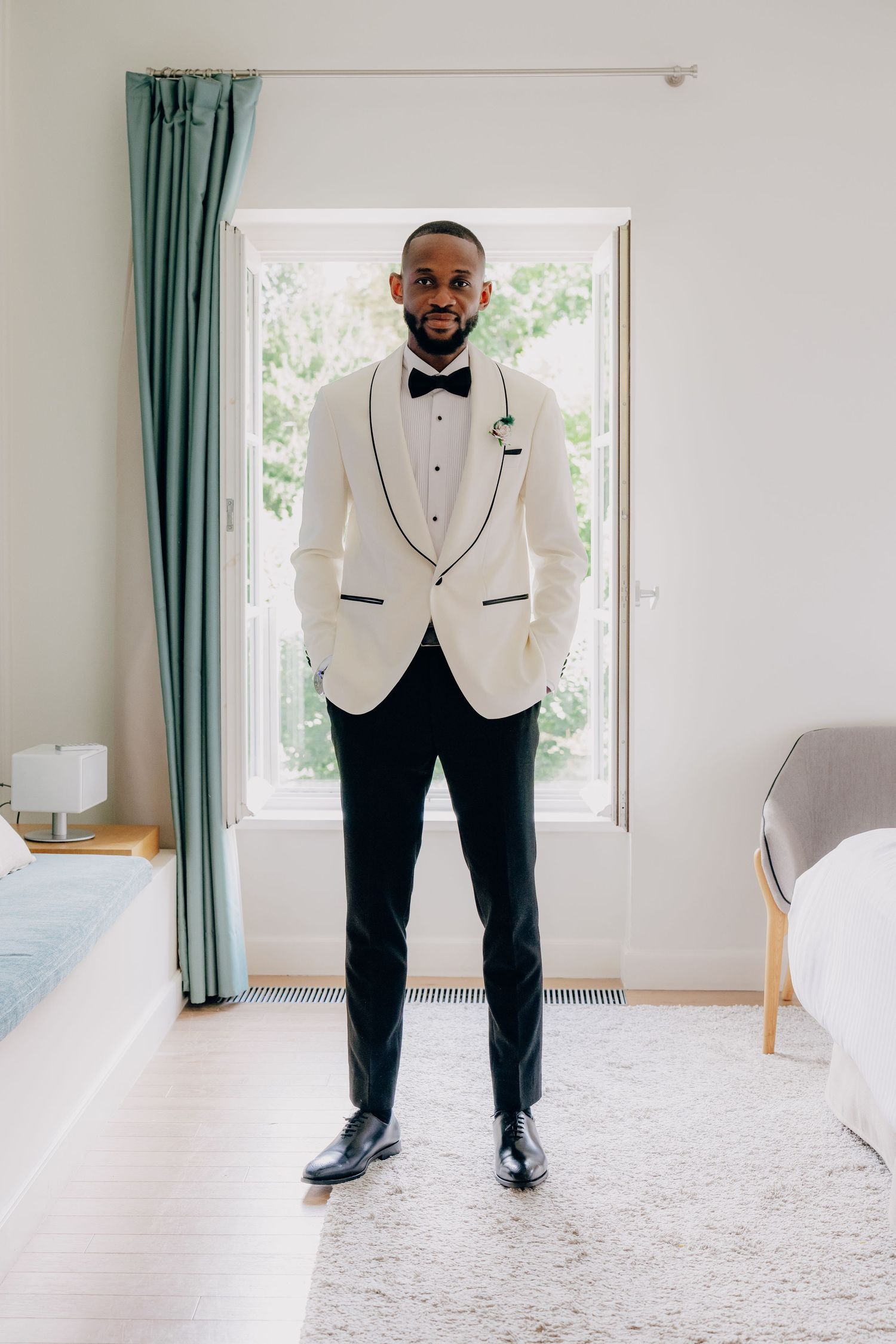 Formal attire displayed in a bright room with teal curtains and white carpet.
