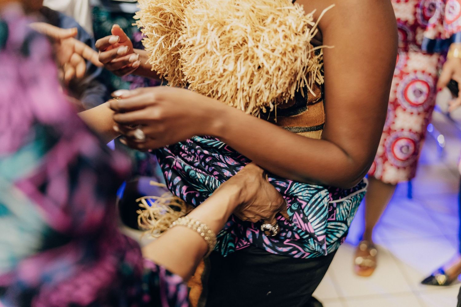A guest in a fringe-detailed outfit checks their phone during a celebration.
