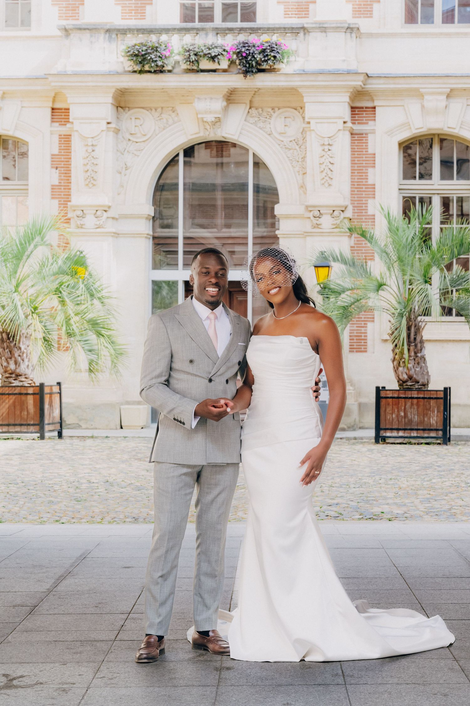 A romantic wedding couple shares joyful moments together in a beautiful courtyard with classic architecture.