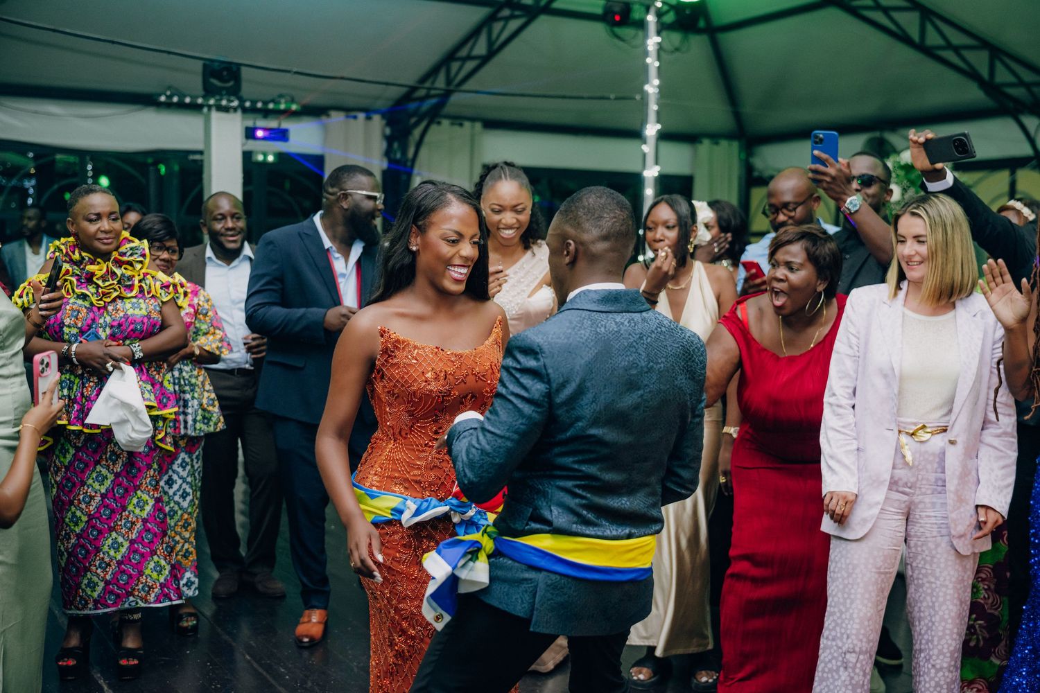 Wedding celebration with guests dancing and cheering during a special moment at the reception.