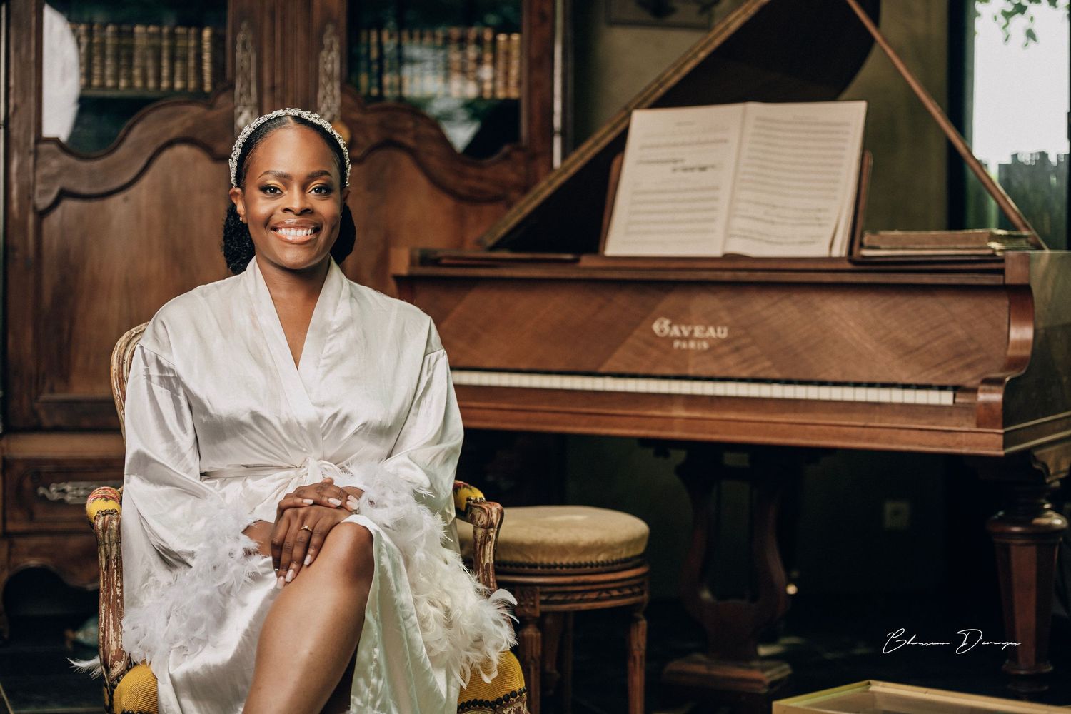Elegant wedding preparation scene with a vintage piano and silk robe in a classic interior setting.