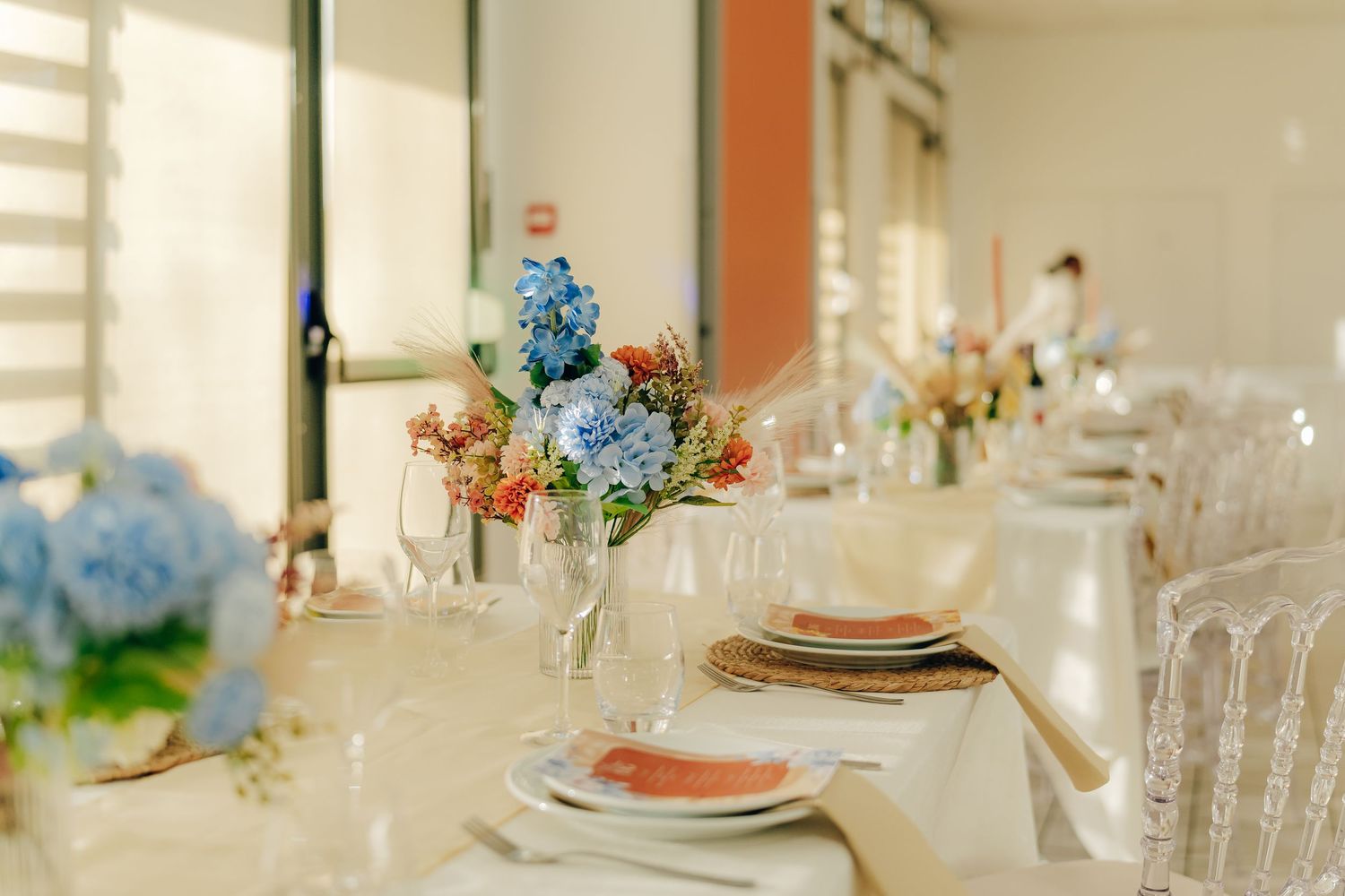 Elegant table setting with blue hydrangeas and delicate glassware at a formal dining event.