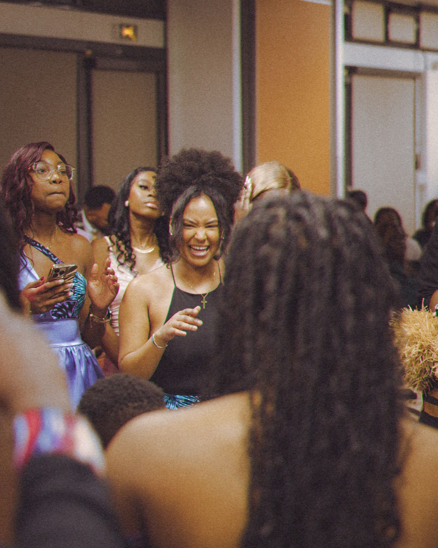 Party guests enjoying themselves at a lively indoor celebration with bright lighting.
