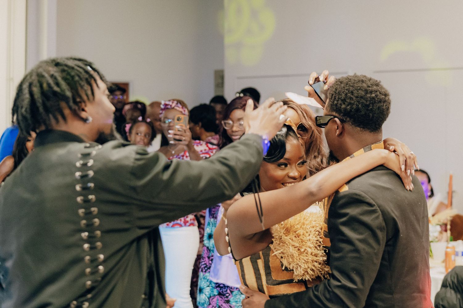 Two people sharing an enthusiastic moment during a celebration while surrounded by onlookers.