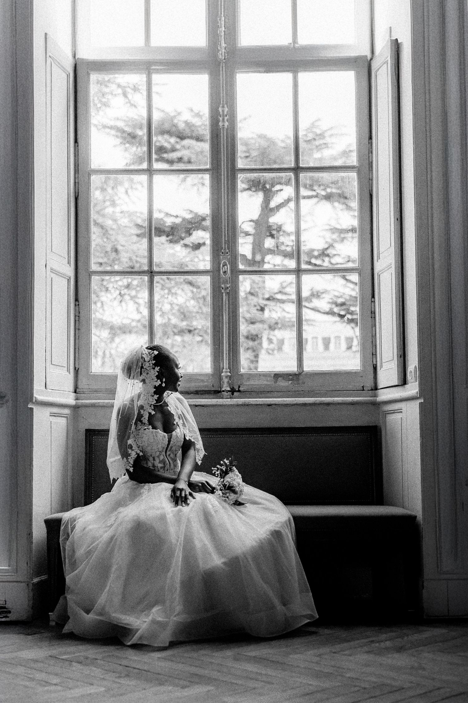A series of black and white photos showing figures in white dresses sitting by windows in an elegant interior space.