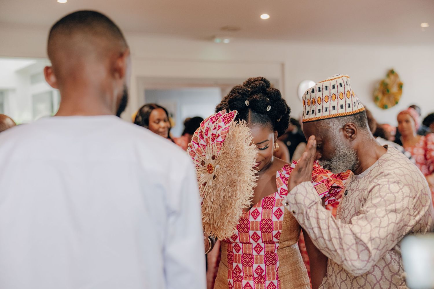 Wedding celebration with guests in traditional African attire dancing and mingling.