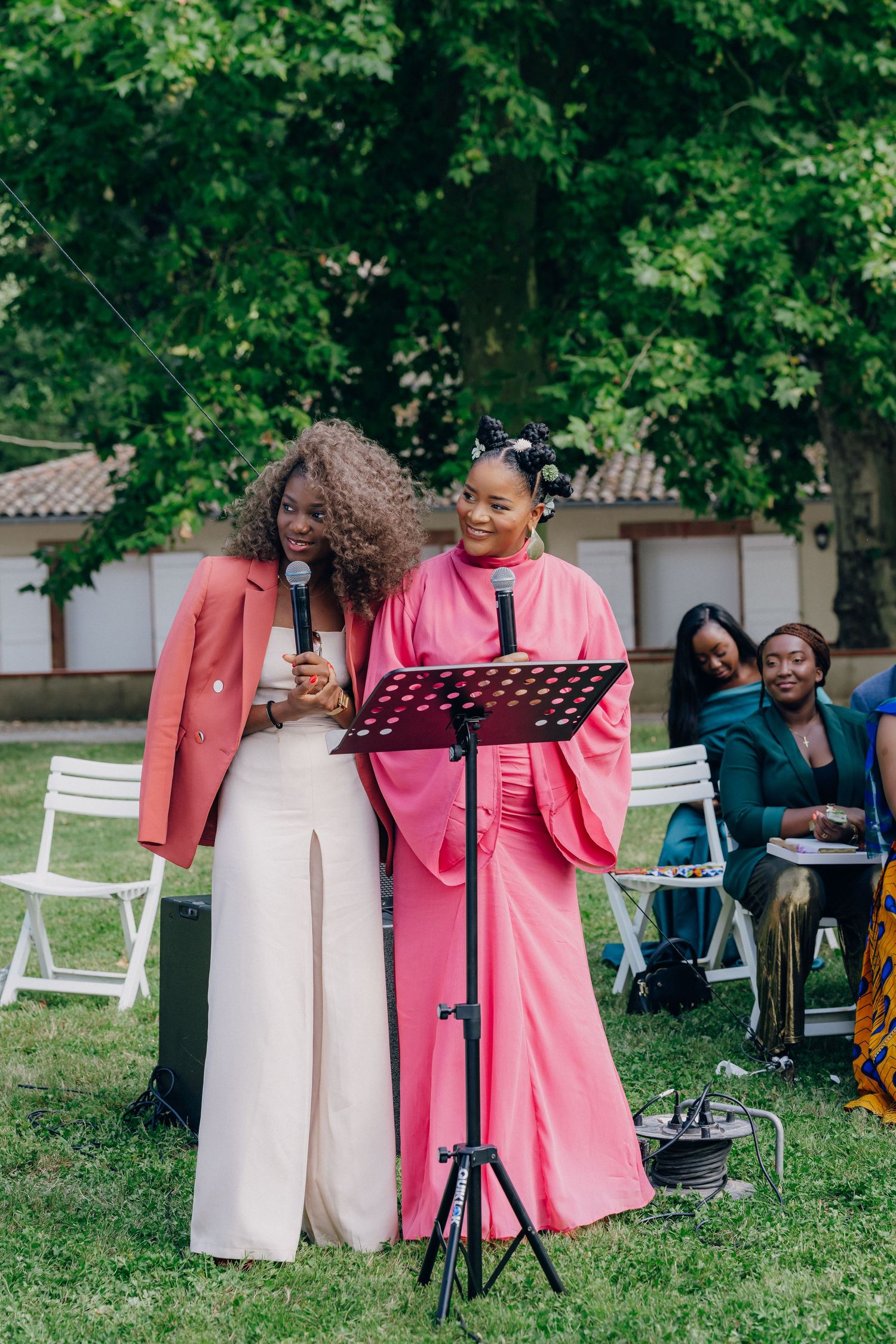 Wedding musicians performing in a garden setting with music stands and pink attire.