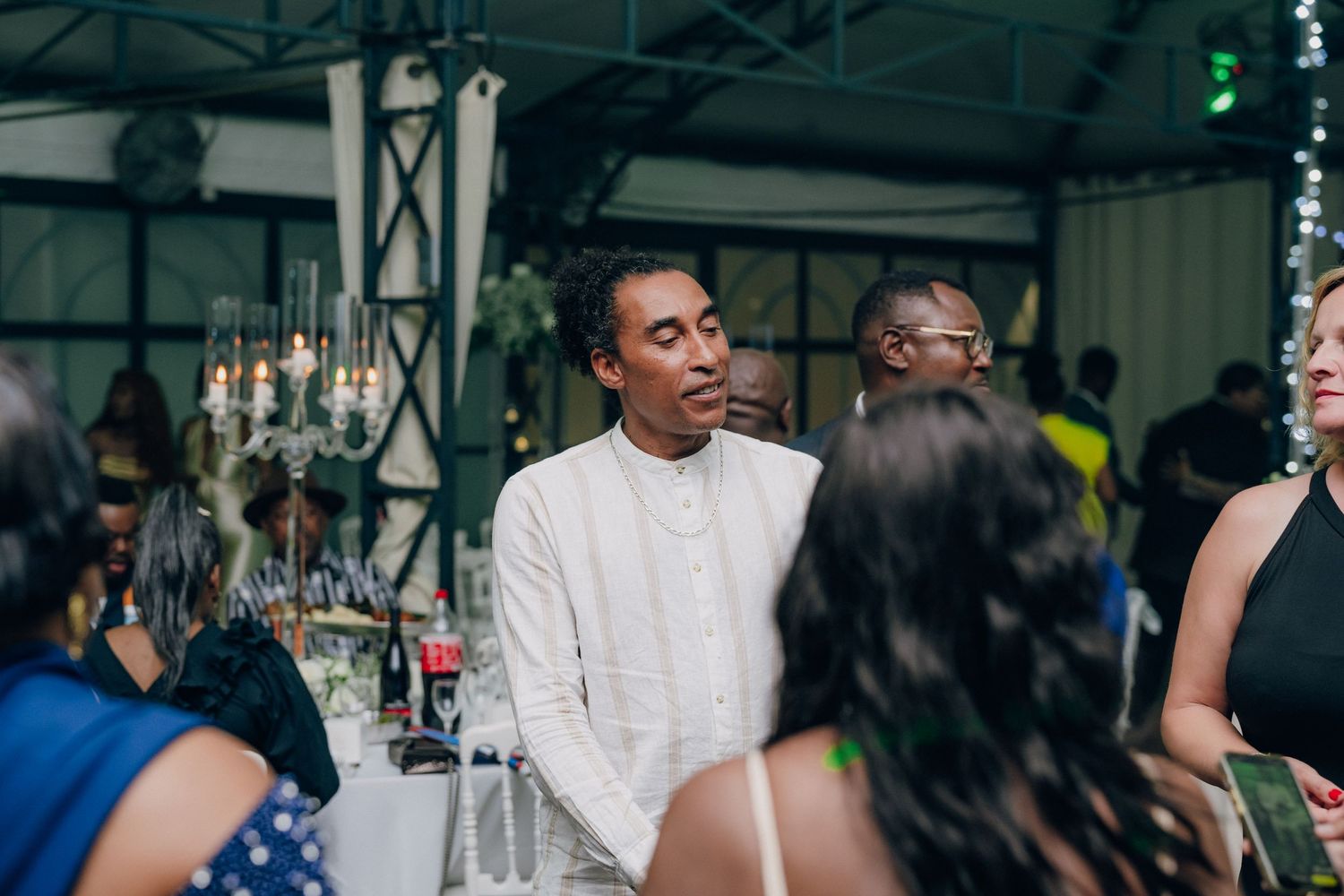 Event venue decorated with elegant lighting and guests mingling during a celebration.