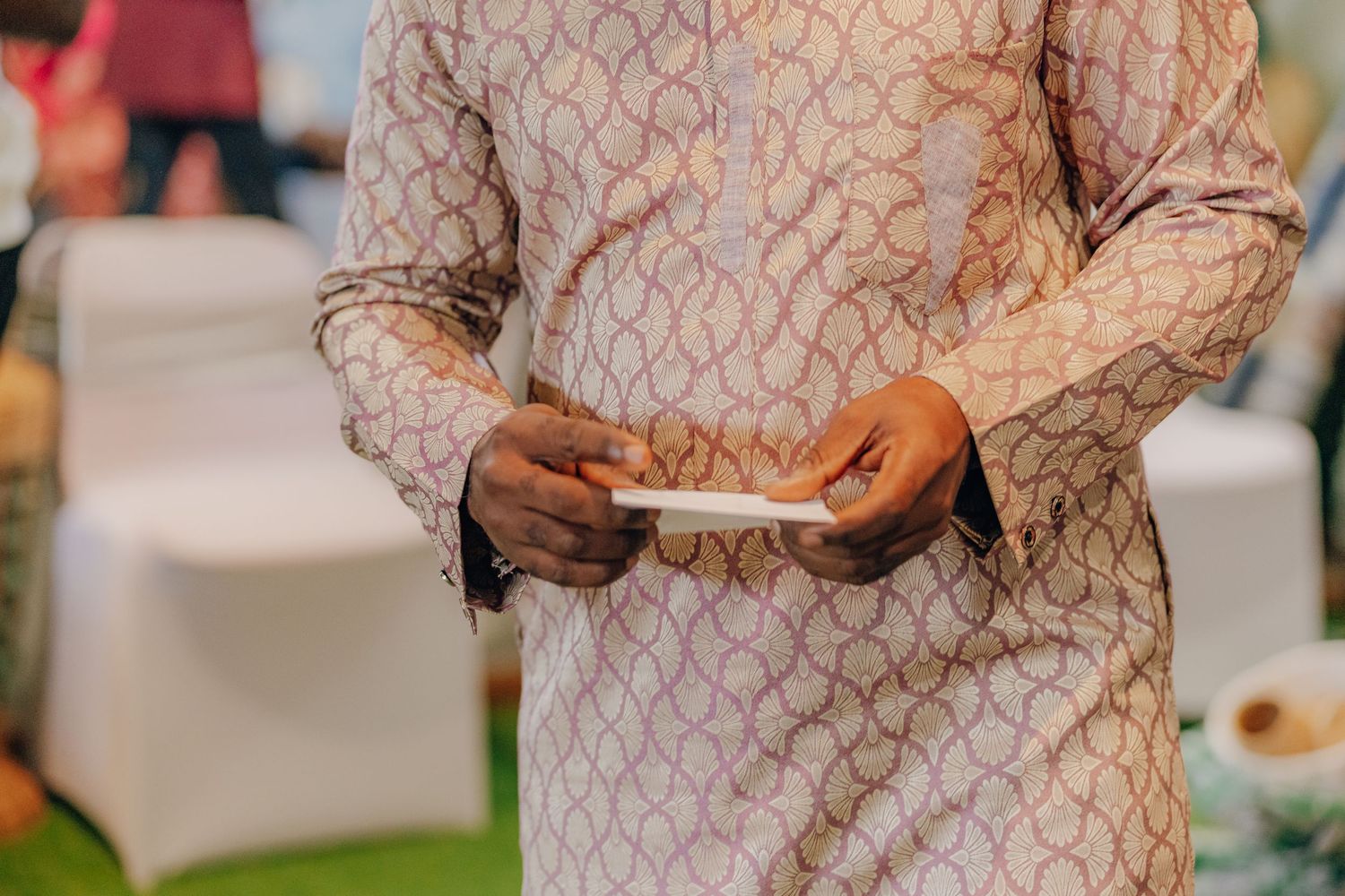 Close-up detail of traditional Nigerian wedding attire with intricate lace patterns and embroidery.