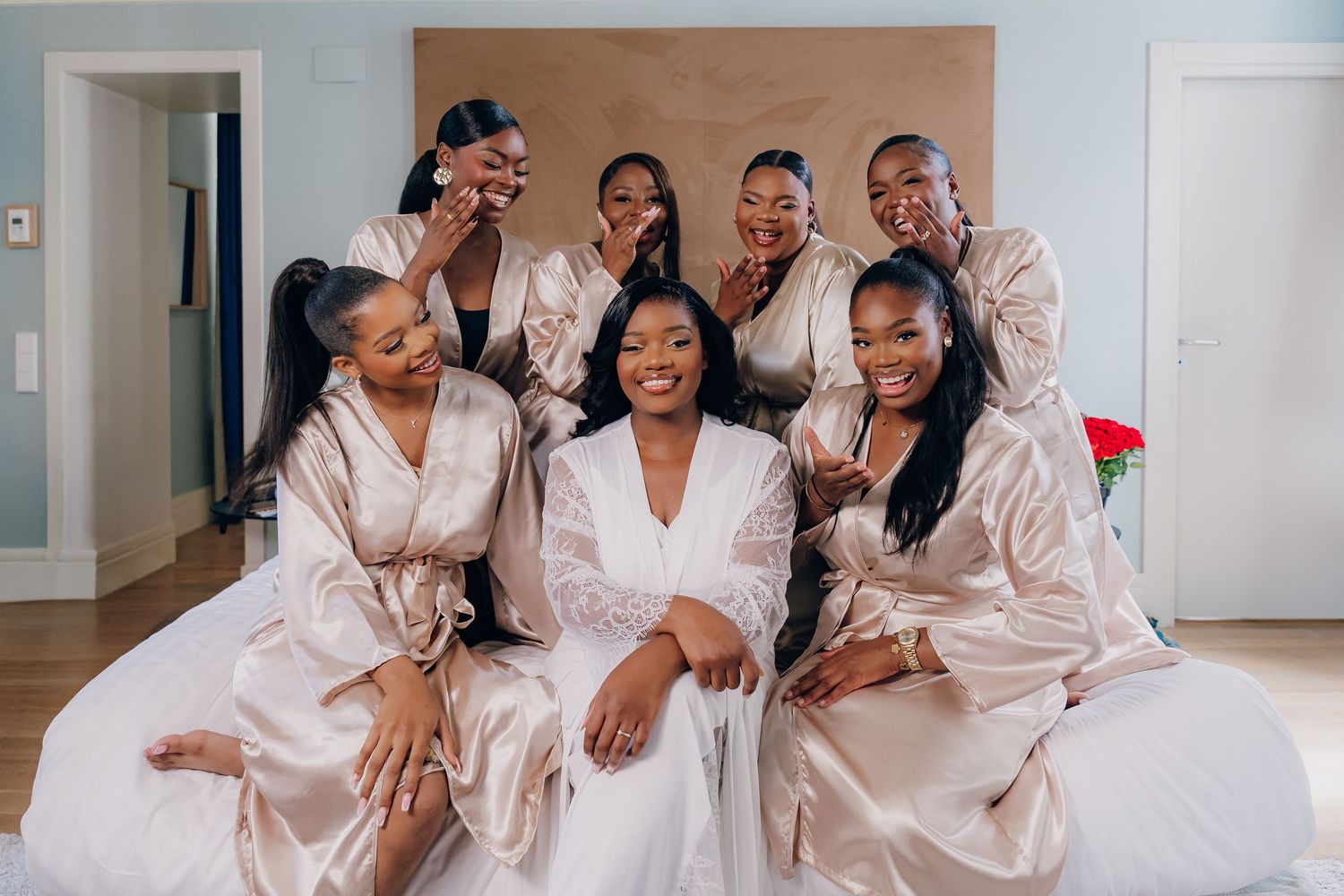 Group celebration moment in matching silk robes during wedding preparations.