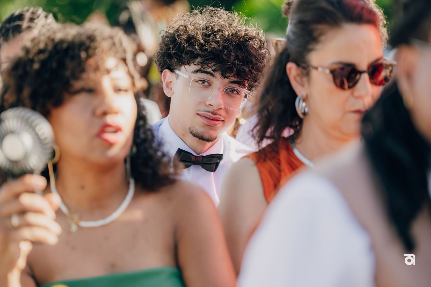 Stylishly dressed wedding guests enjoying themselves during an outdoor celebration.
