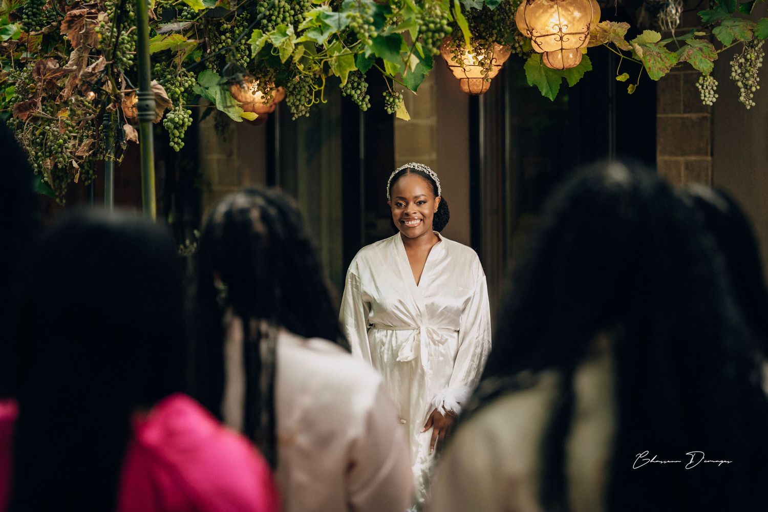 An intimate wedding preparation scene with decorative pendant lamps hanging from above in a dimly lit room.