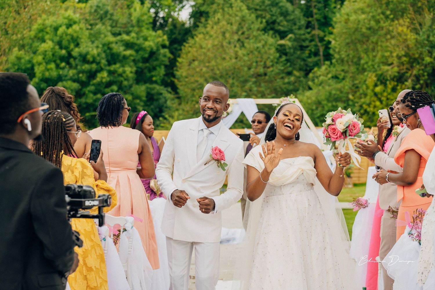 Newlyweds celebrate during their outdoor garden wedding with guests in colorful attire.