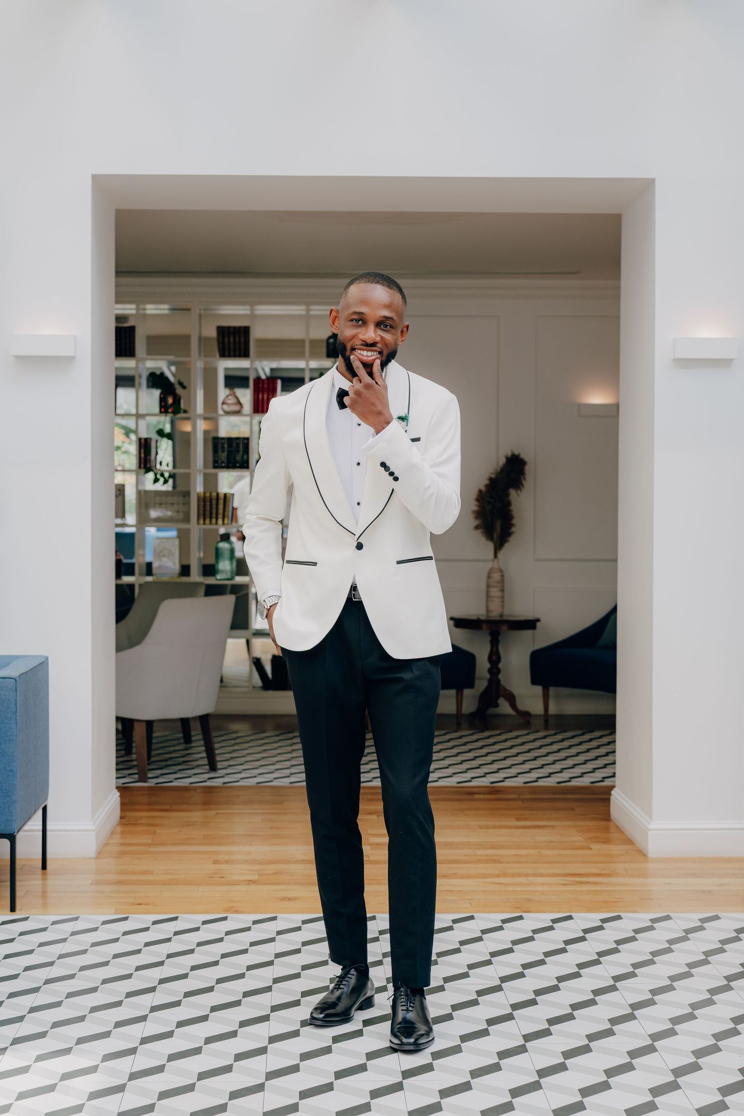 A series of photos showing someone in a white dinner jacket and black pants posing in an elegant room with checkered floors.