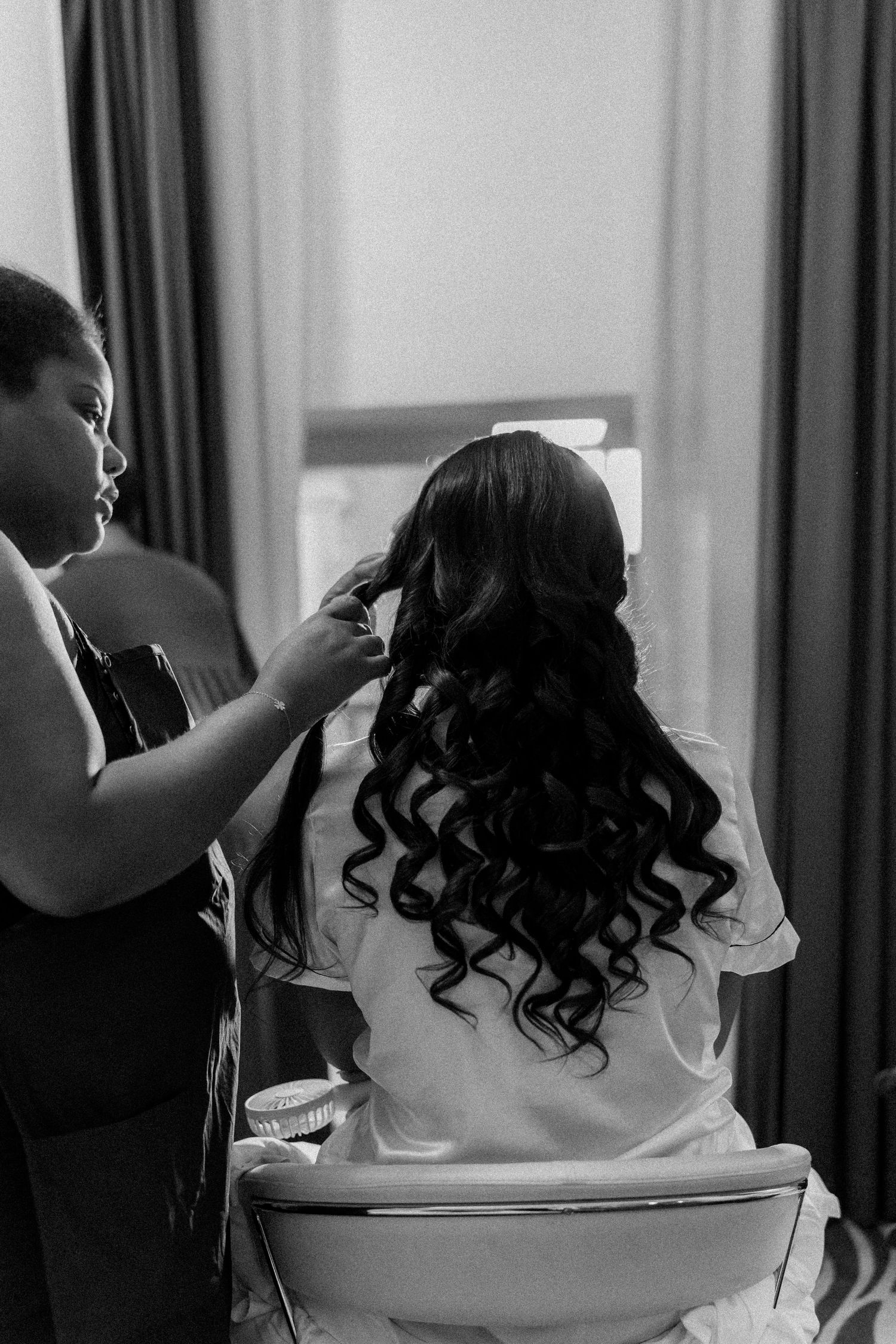 Behind the scenes shots of wedding preparations with a person in white getting their hair styled.