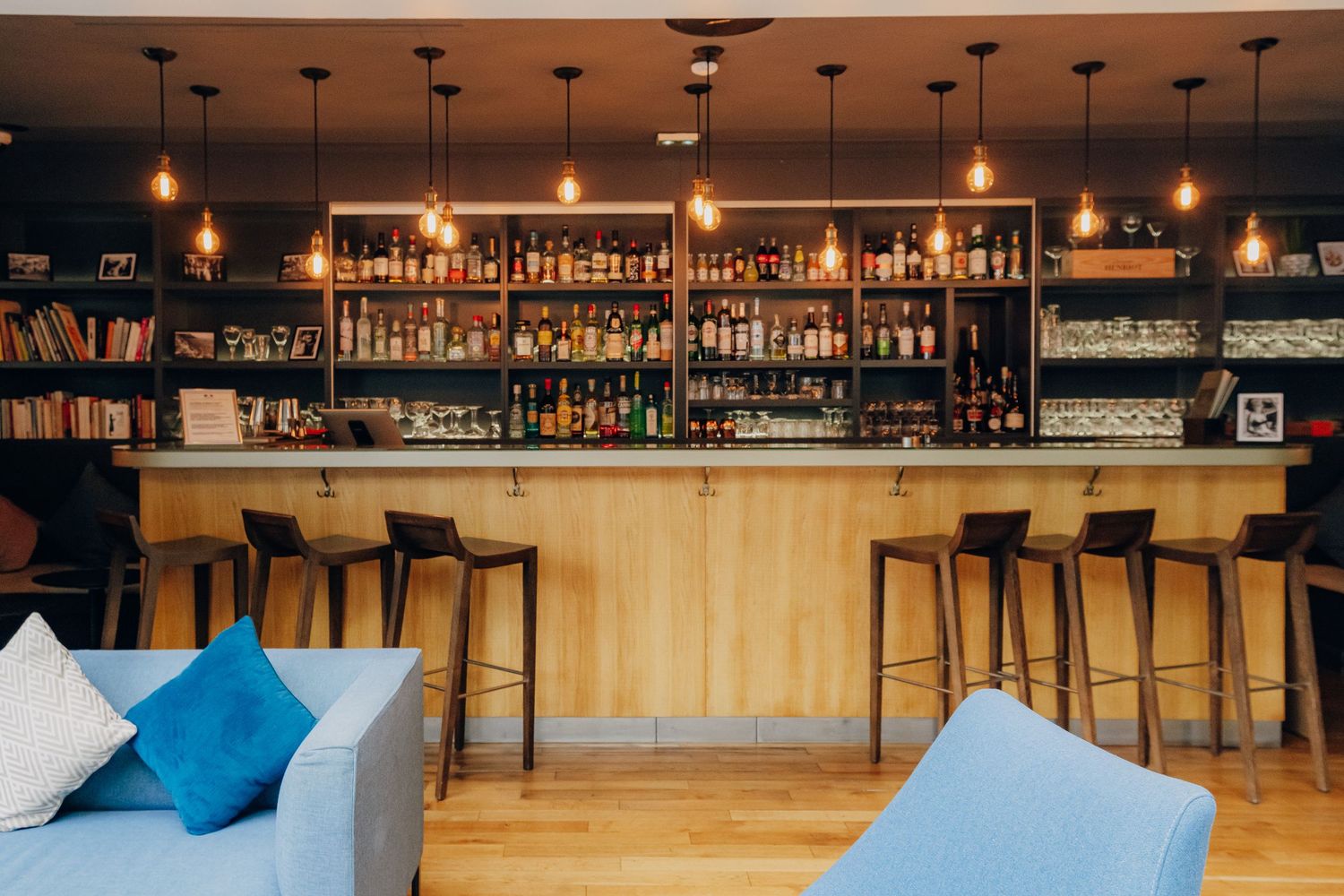 Modern bar interior with pendant lighting and wooden accents creates an elegant ambiance.