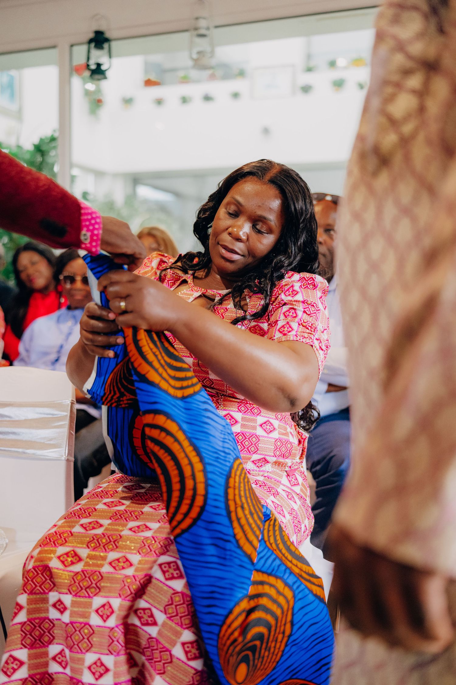A celebration scene showing vibrant African print clothing and festive decorations.