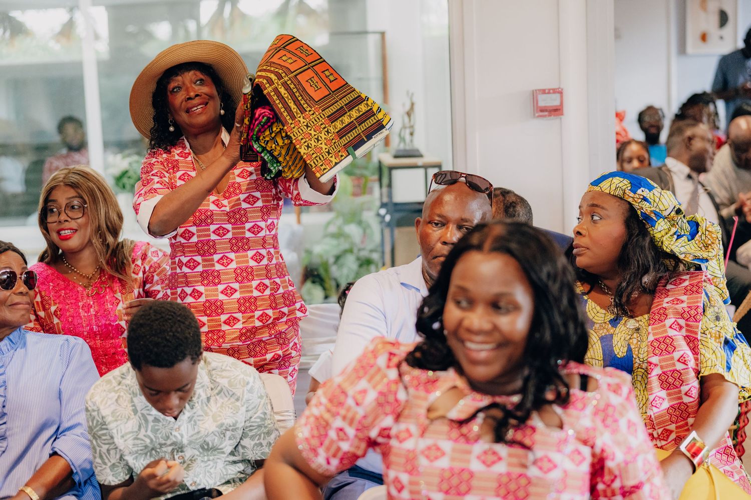 Group celebration event with attendees wearing colorful traditional African prints and festive attire.